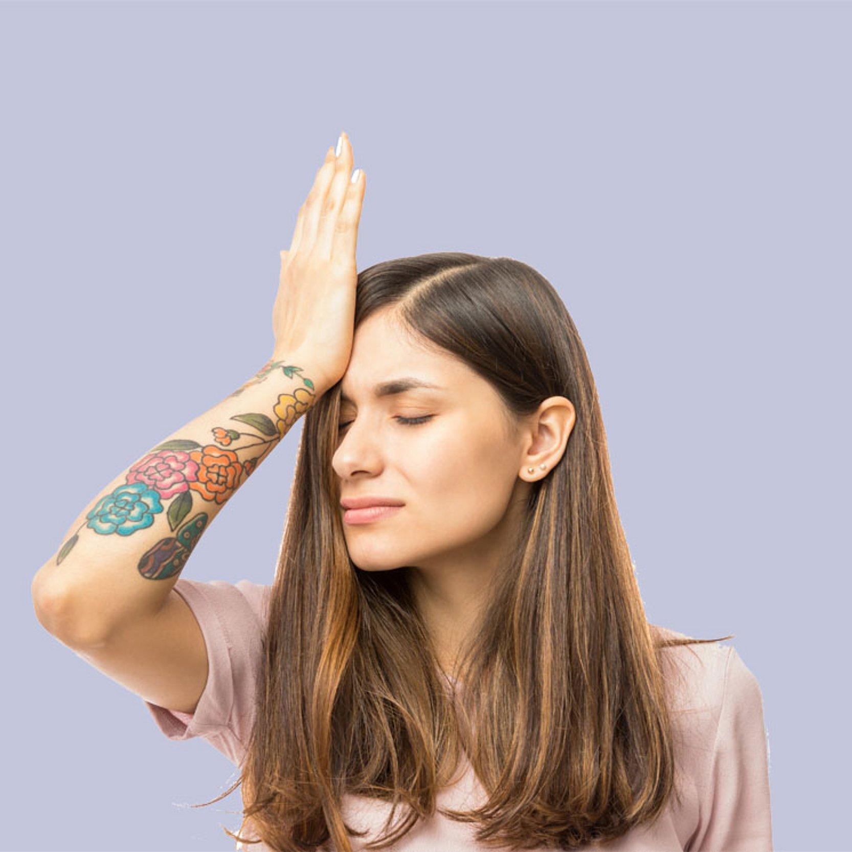 Reue Eine Frau hält sich die Hand vor den Kopf