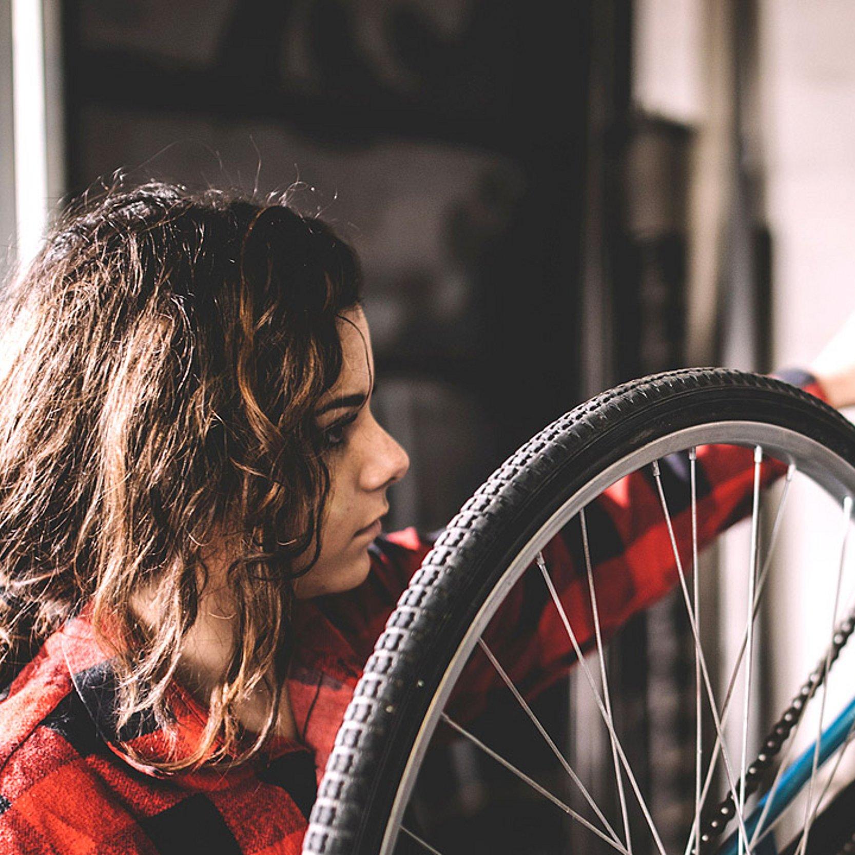 Jugendwerkstatt Gießen  Eine junge Frau repariert ein Fahhrad