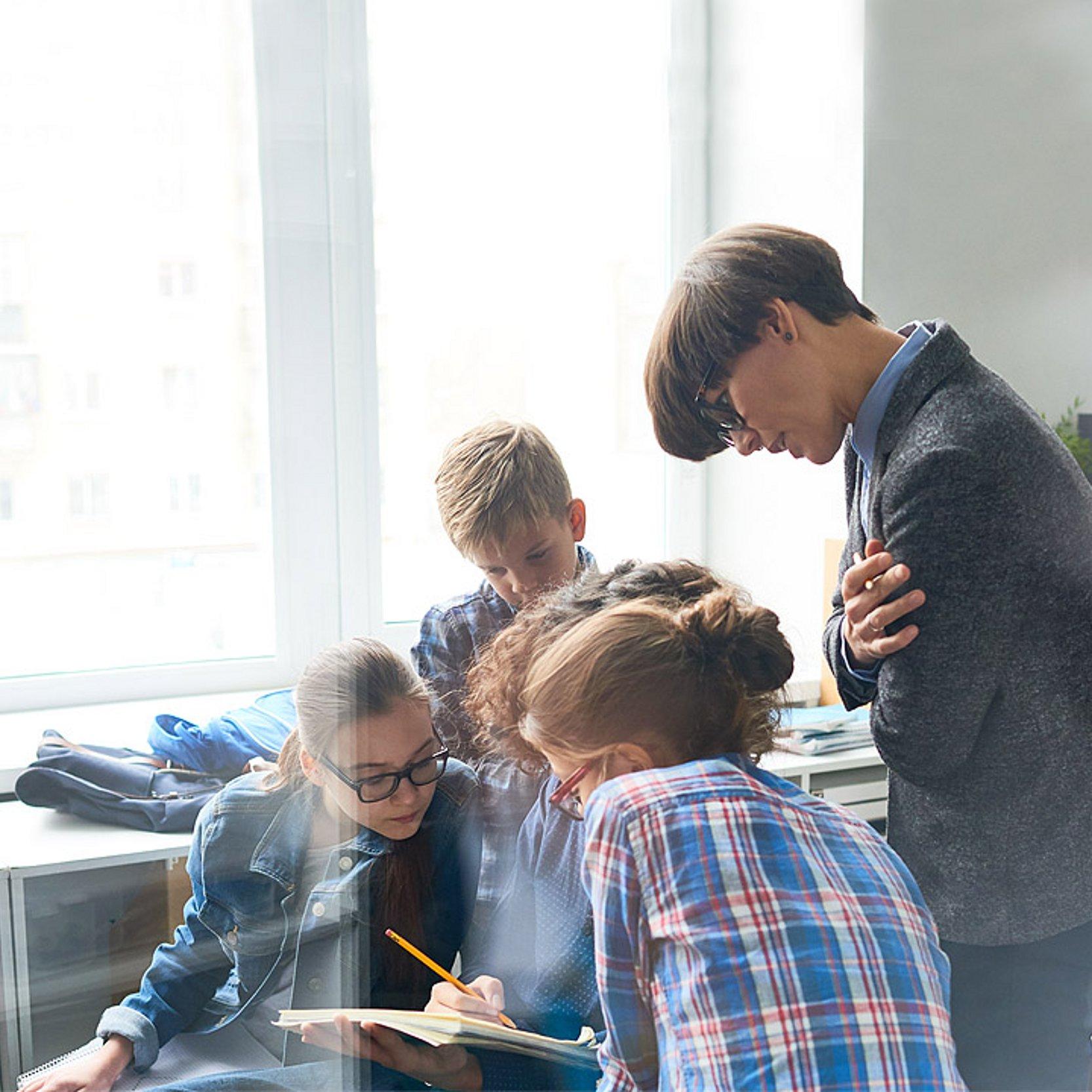 Schulprojekt Schüler arbeiten an einem Projekt, sitzen zusammen und sprechen miteinander