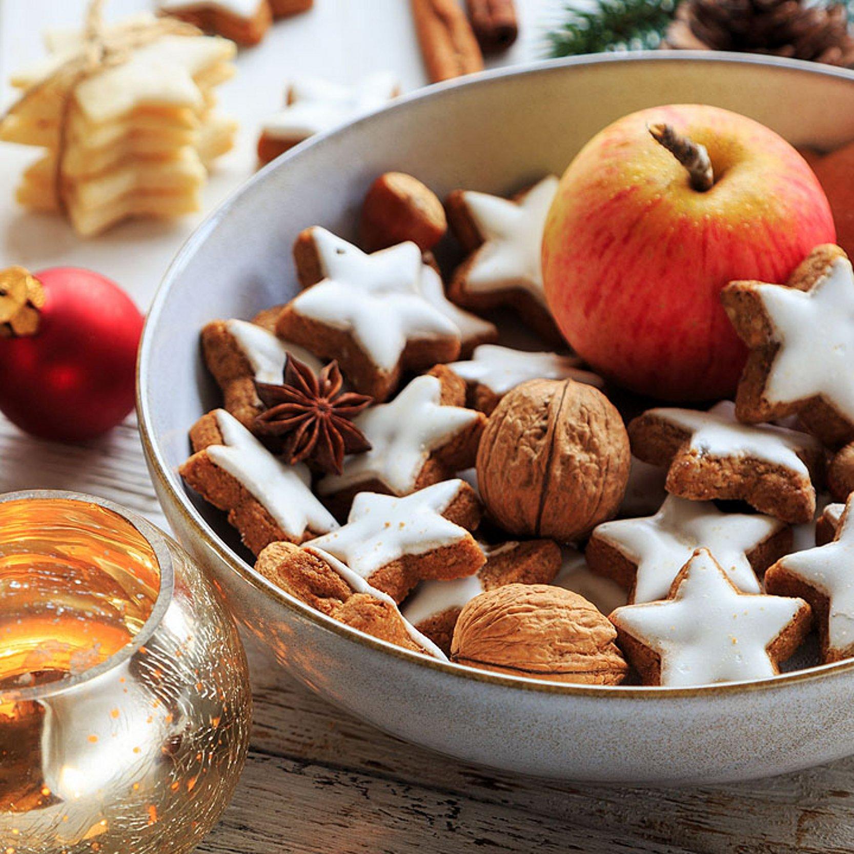 Zimtsterne im Advent Schale mit Zimtsternen und einem Apfel