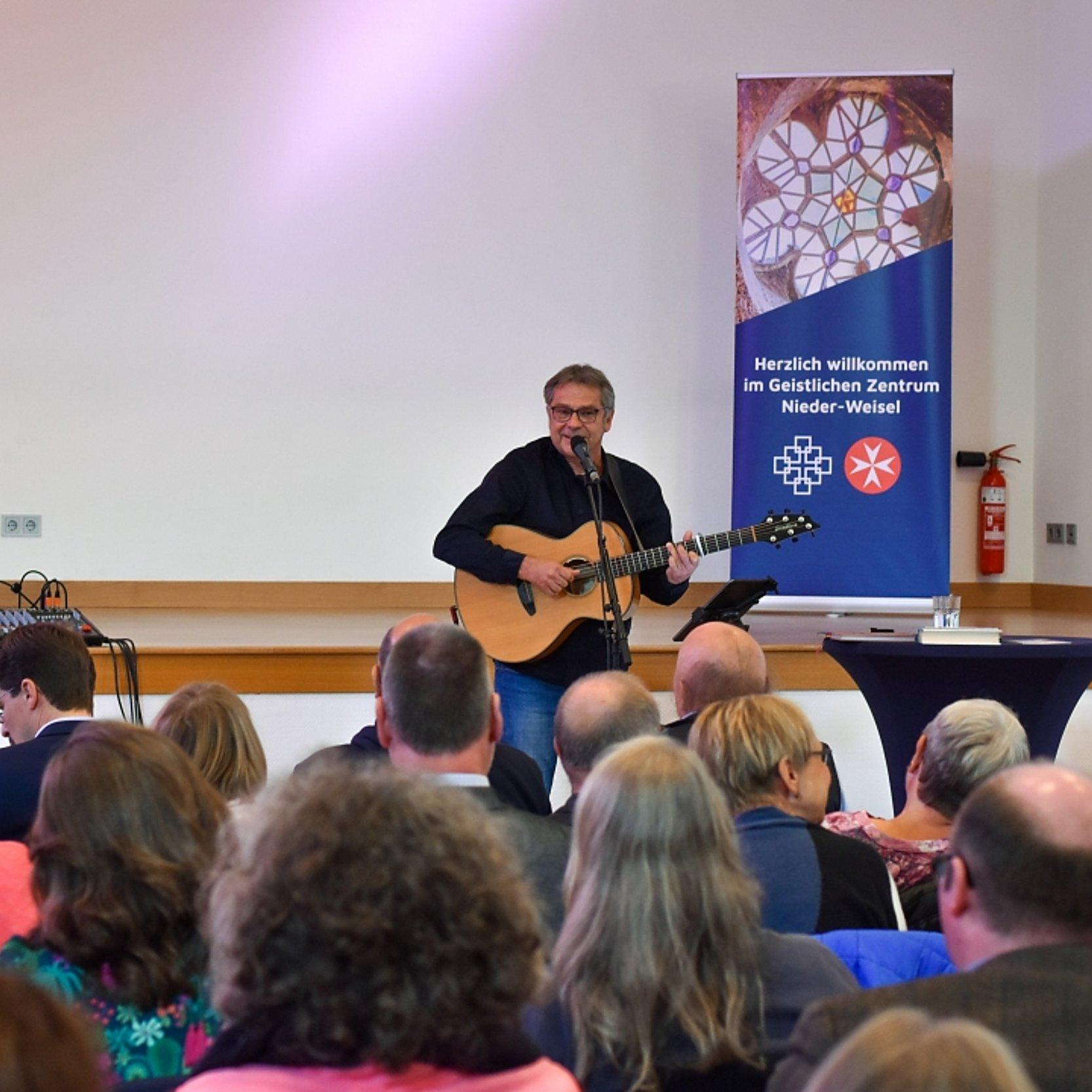 Spirituelle Kirche 2025 Buchholz Buchholz mit Gitarre auf der Bühne