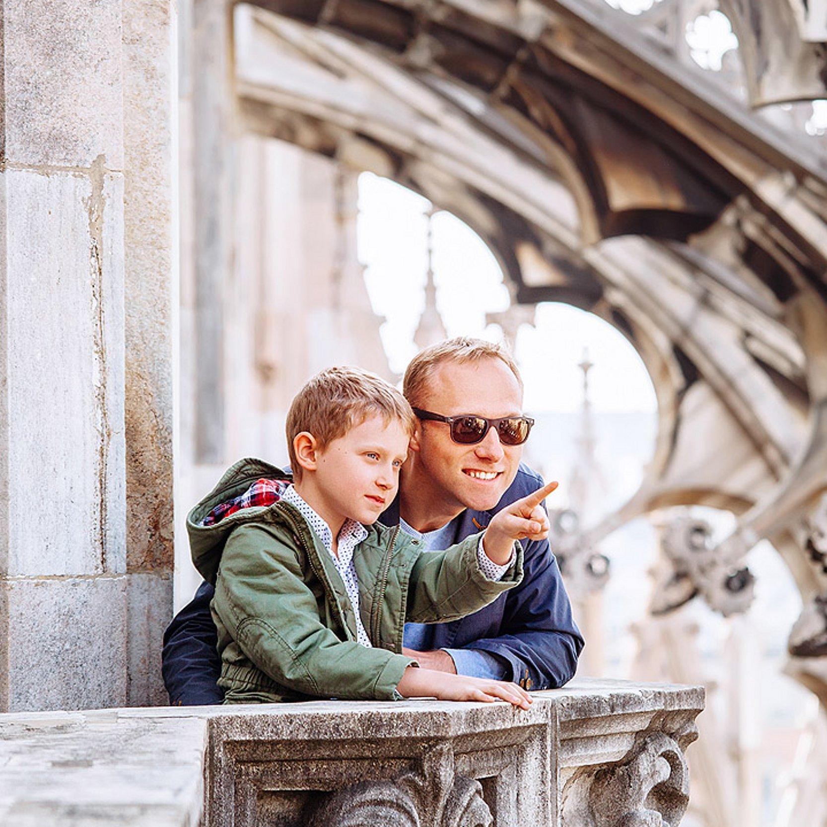 Kirchturm Vater und Sohn auf einer Zwischenstation während einer Kirchturmbesteigung - beide sind vertraut und blicken in die Ferne