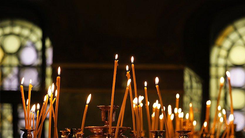 Kerzen Brennende, lange, gelbe Kerzen in einer Kirche