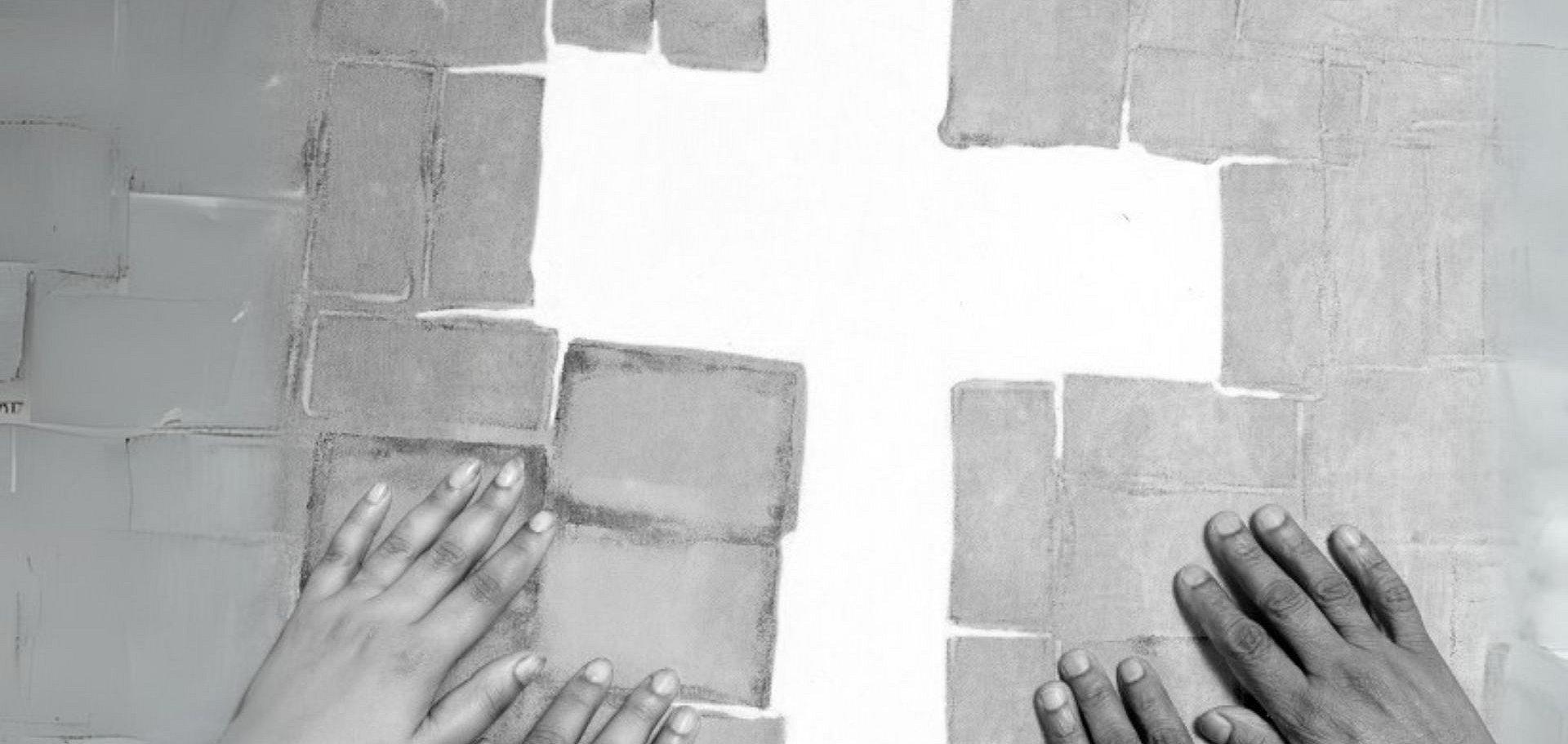 Viele Händer suchen Halt an einem Kreuz