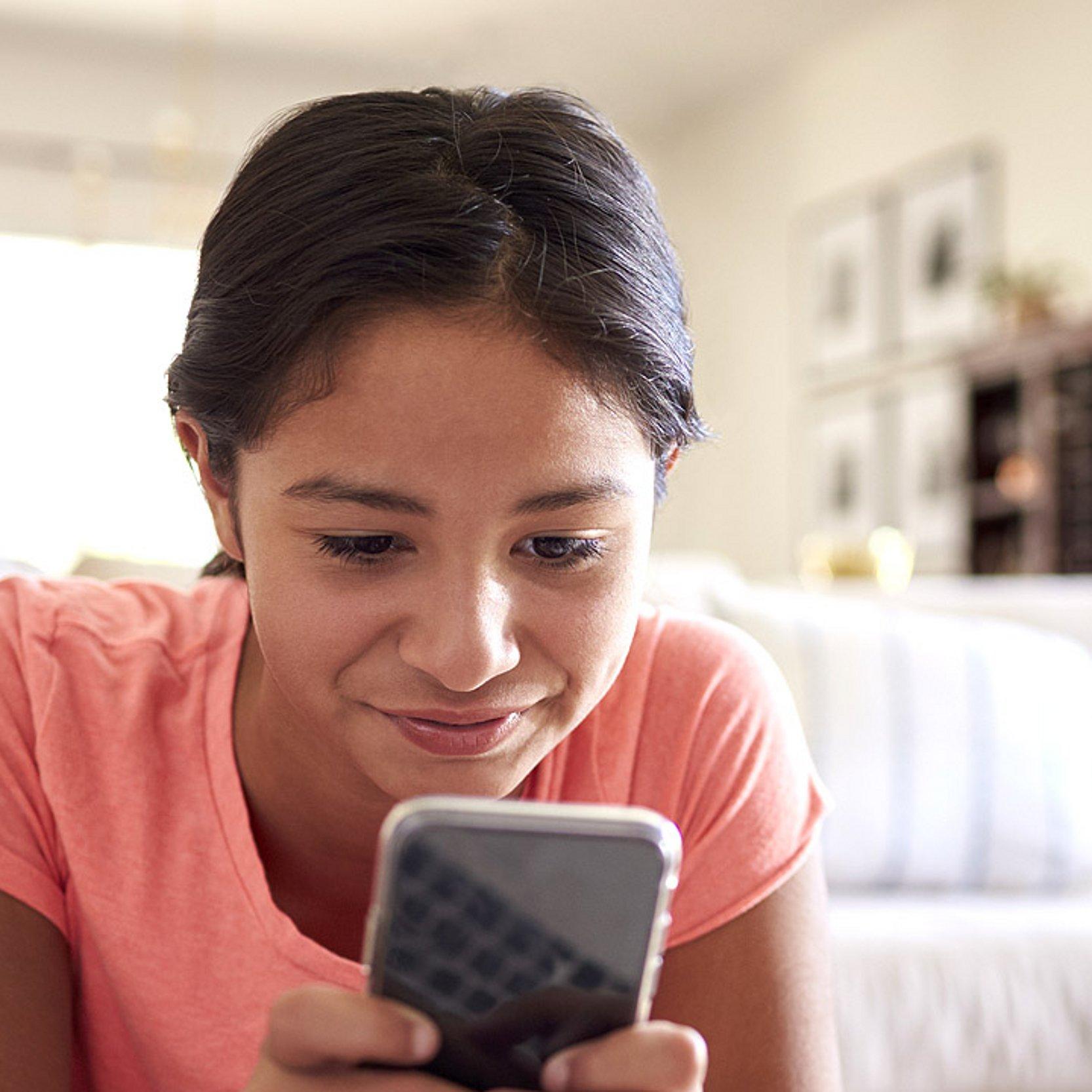 Jugendliche Ein Mädchen schaut in ein Smartphone