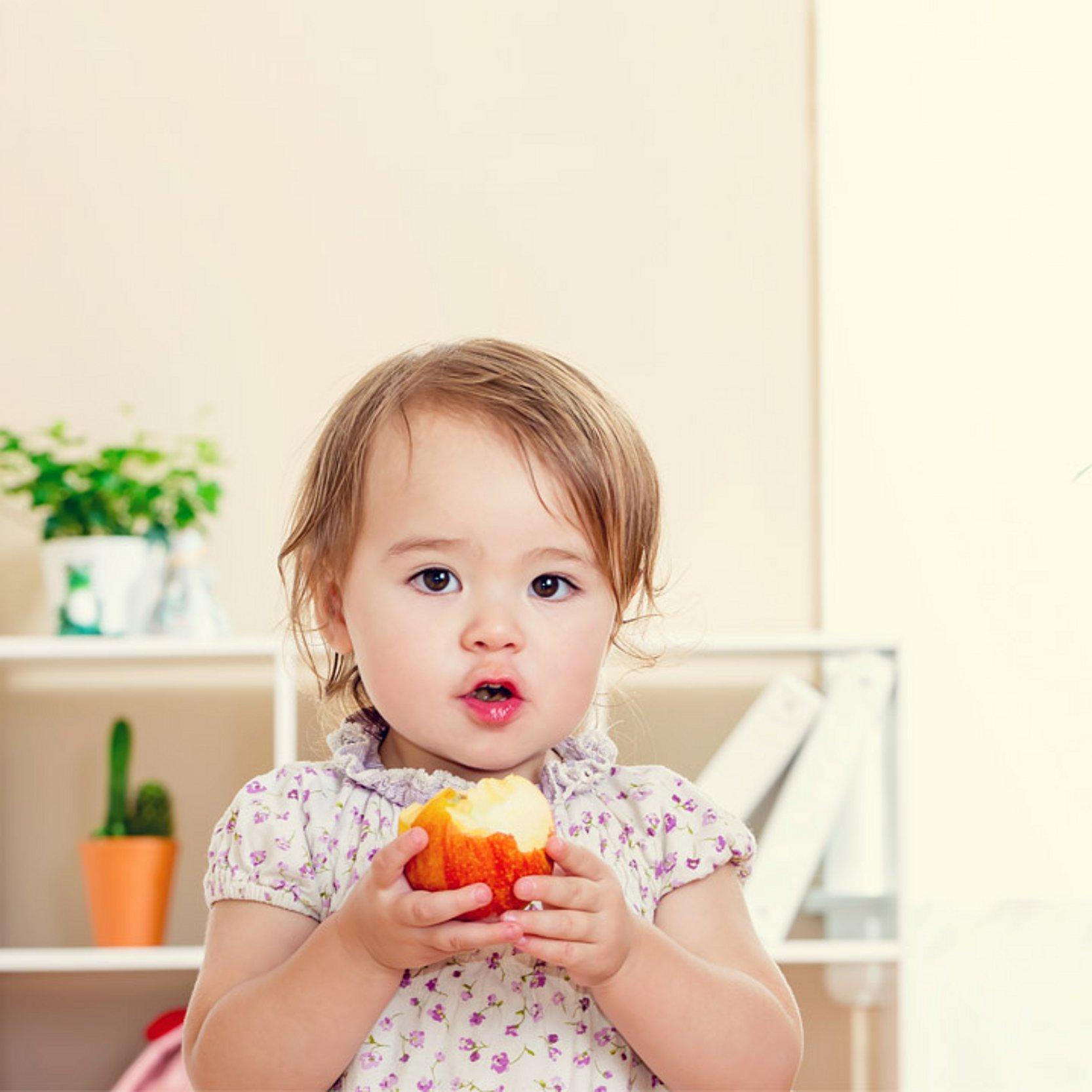 Kind isst Apfel Ein kleines Mädchen isst einen Apfel