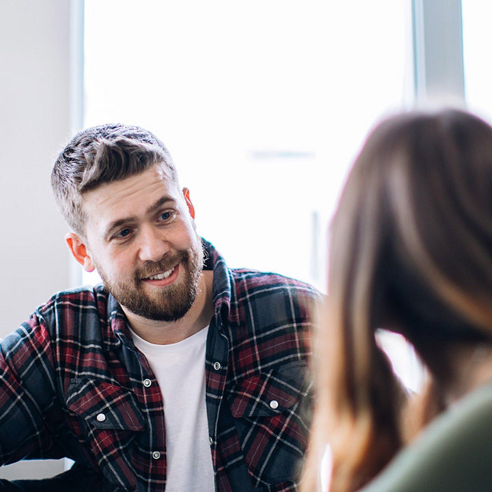Mentale Gesundheit Ein jüngerer Mann (Sozialarbeiter) berät eine Schülerin