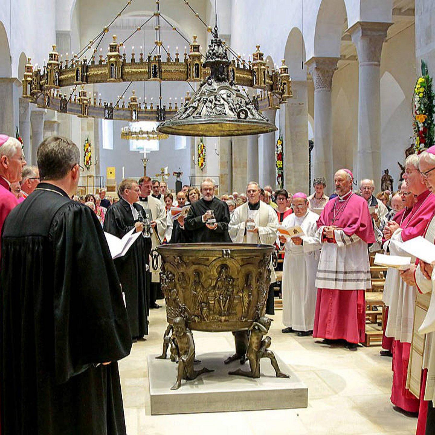 Pfarrer verschiedener Kirchen mit violetten, weißen und schwarzen Talaren bei einer ökumenischen Tauffeier im Hildesheimer Dom 