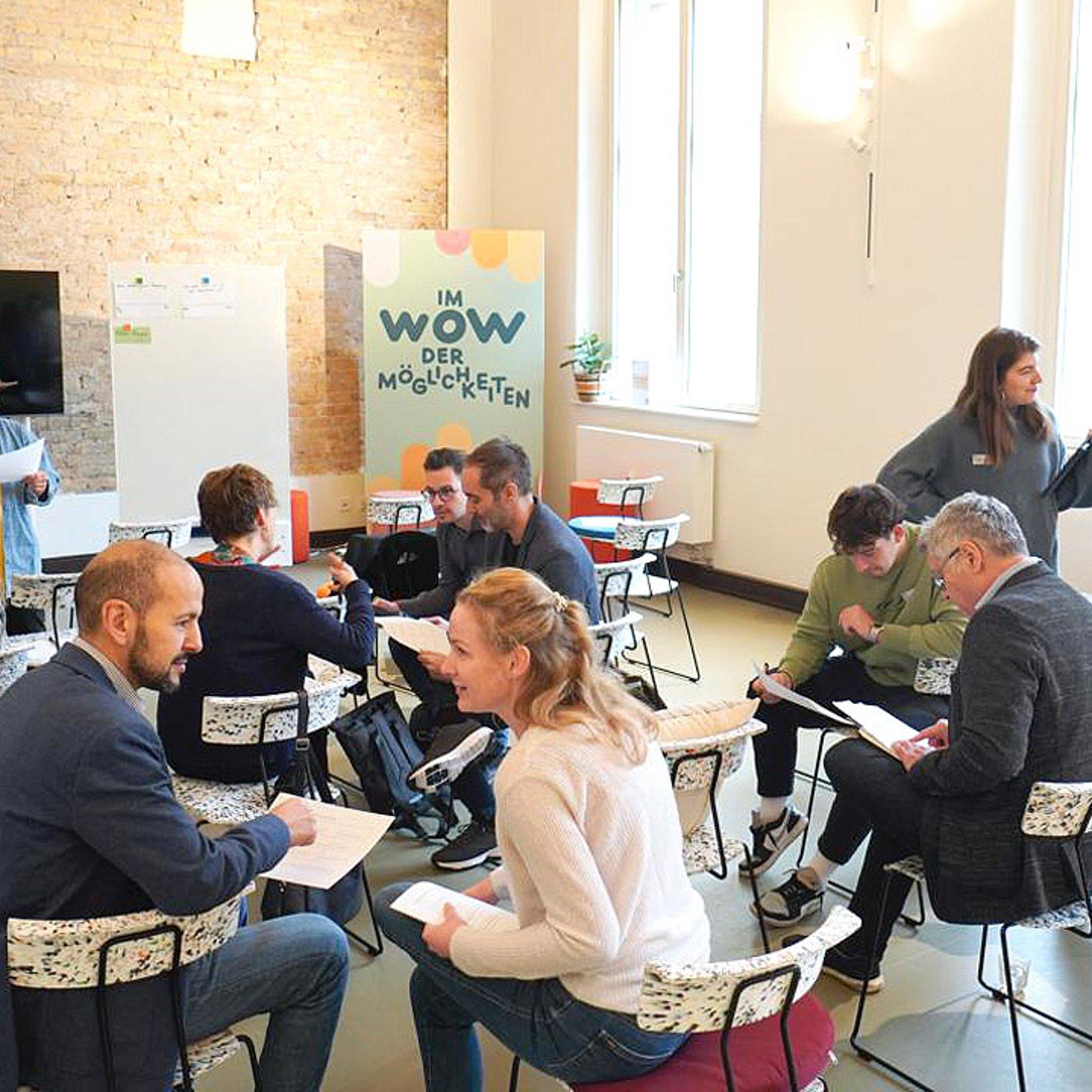 M Menschen sitzen bei einem Workshop zusammen