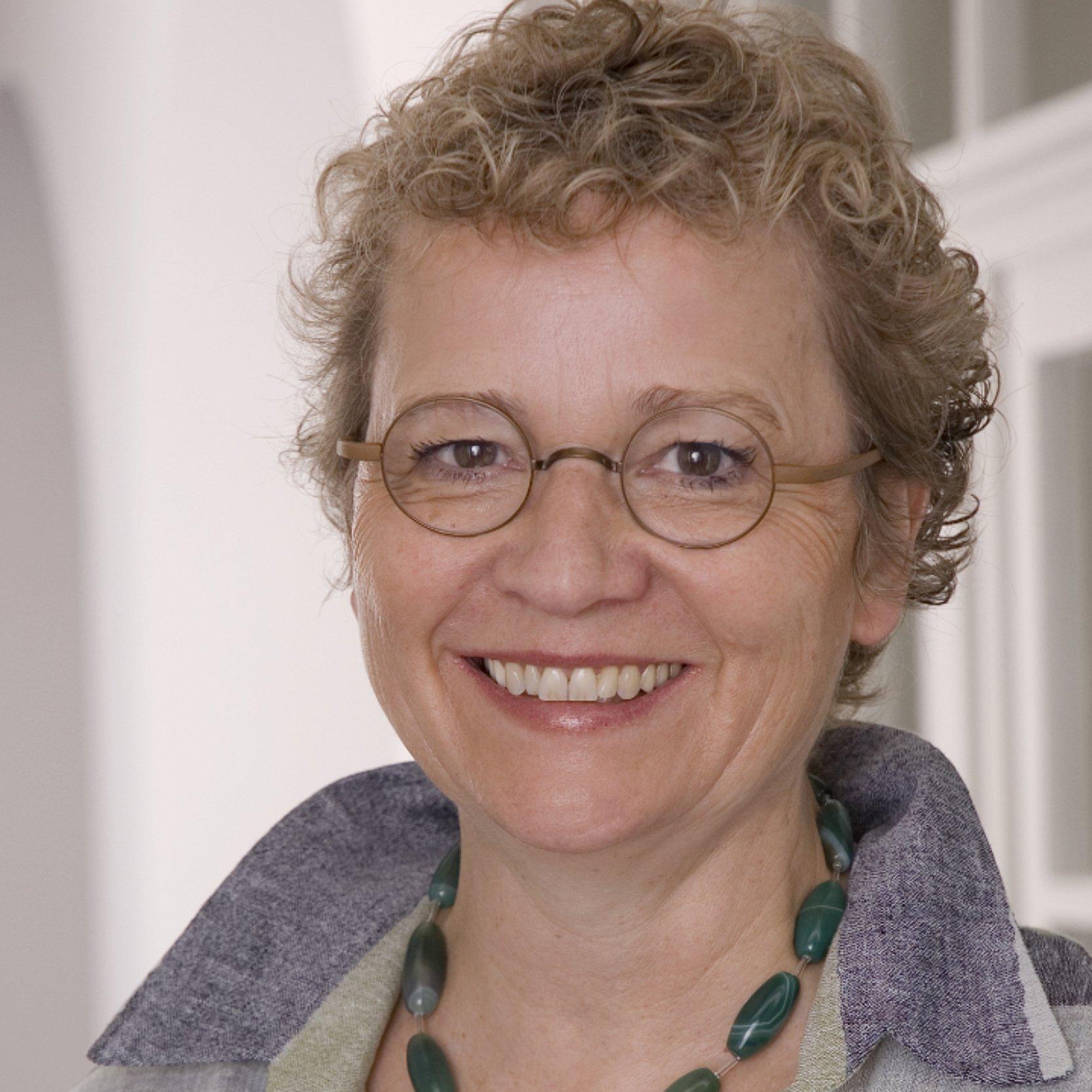 Sigrid Bernhardt-Müller Leiterin der Kirchenverwaltung der EKHN Sigrid Bernhardt-Müller lächelt ins Bild, von ihr sind nur der Kopf zu sehen, sie hat lockige Haare und trägt eine Brille