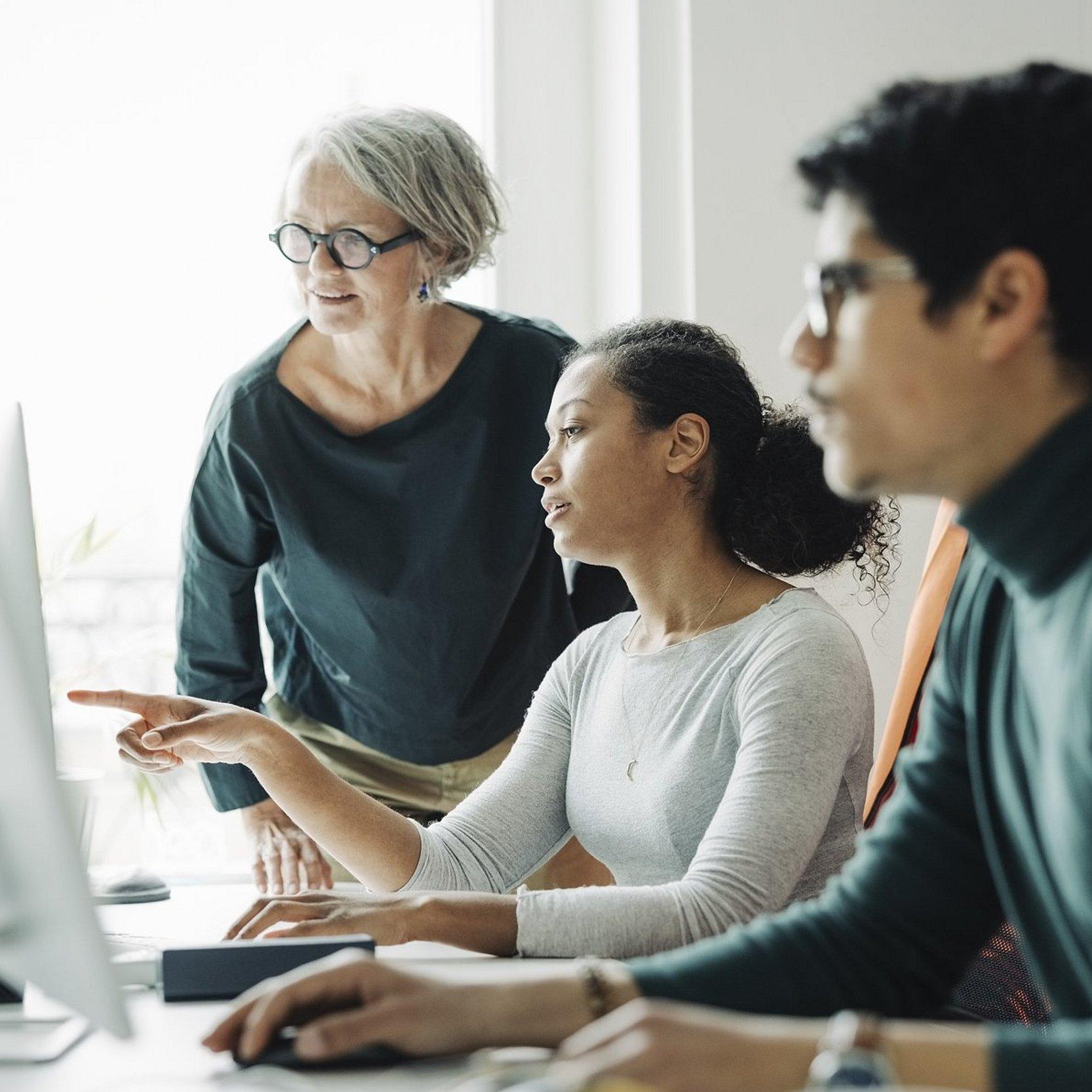 Datenschtuz im Gemeindebüro Zwei Frauen und ein Mann schauen auf einen Bildschirm.