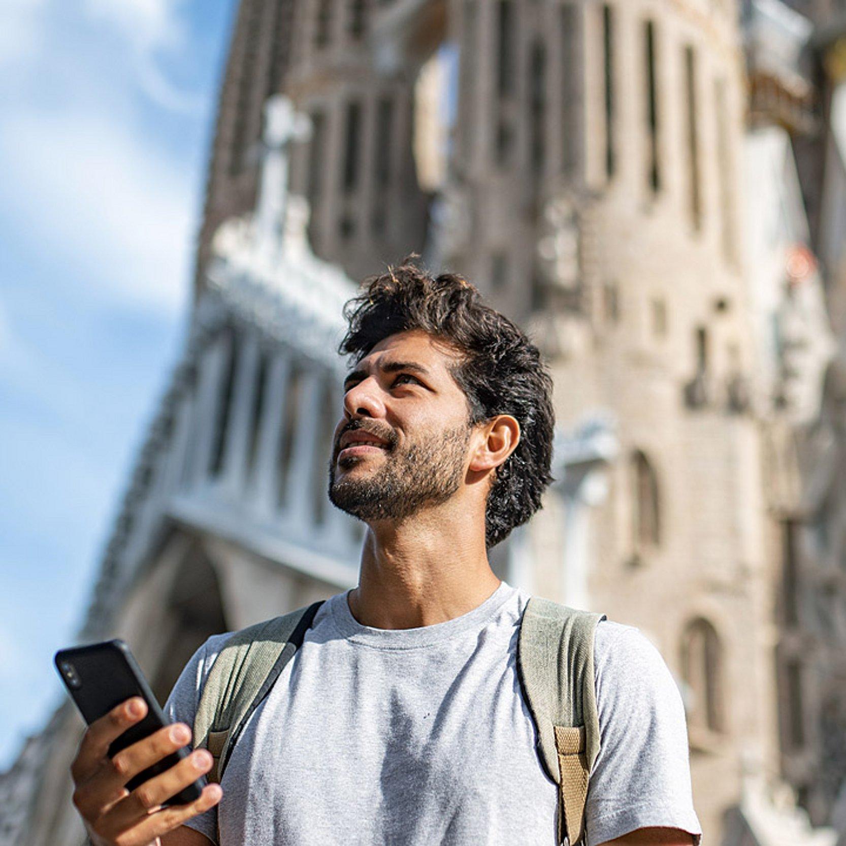 Sagrada Família Junger Mann mit Smartphone vor der Sagrada Família