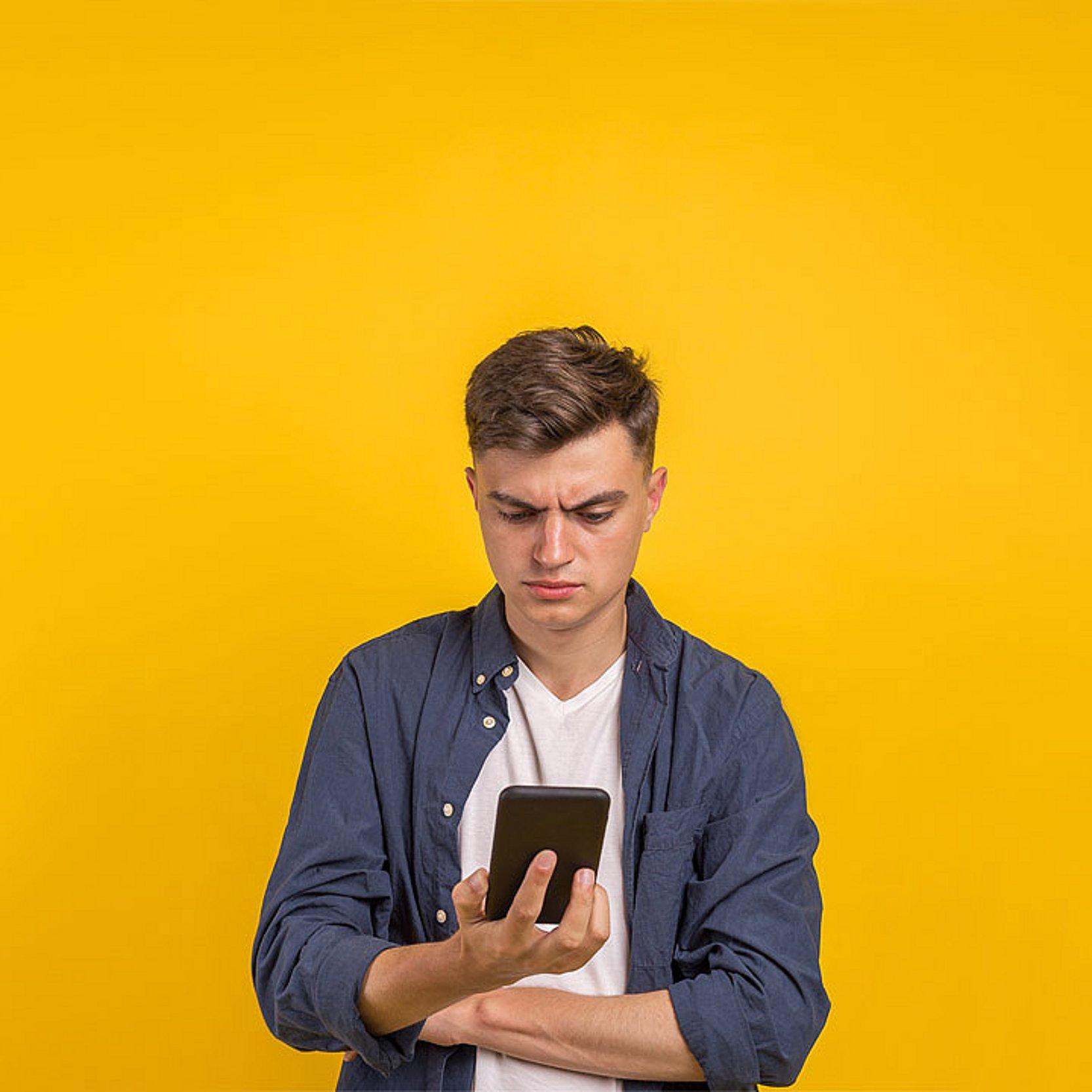 Nachrichten checken Ein junger Mann checkt die Nachrichten auf seinem Smartphone