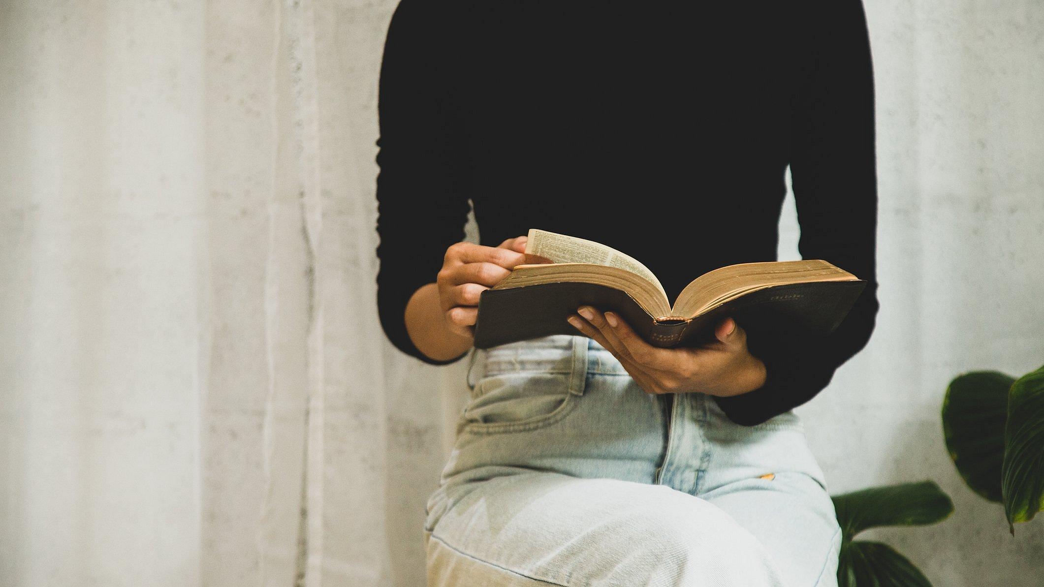 Auszeit für Pfarrer:innen Frau sitzt und liest in der Bibel.