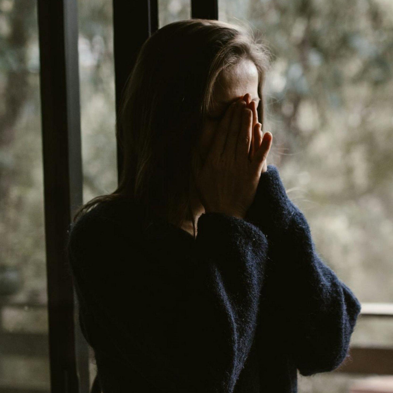 Weinende Frau Frau hält sich ihre Hände vor das Gesicht