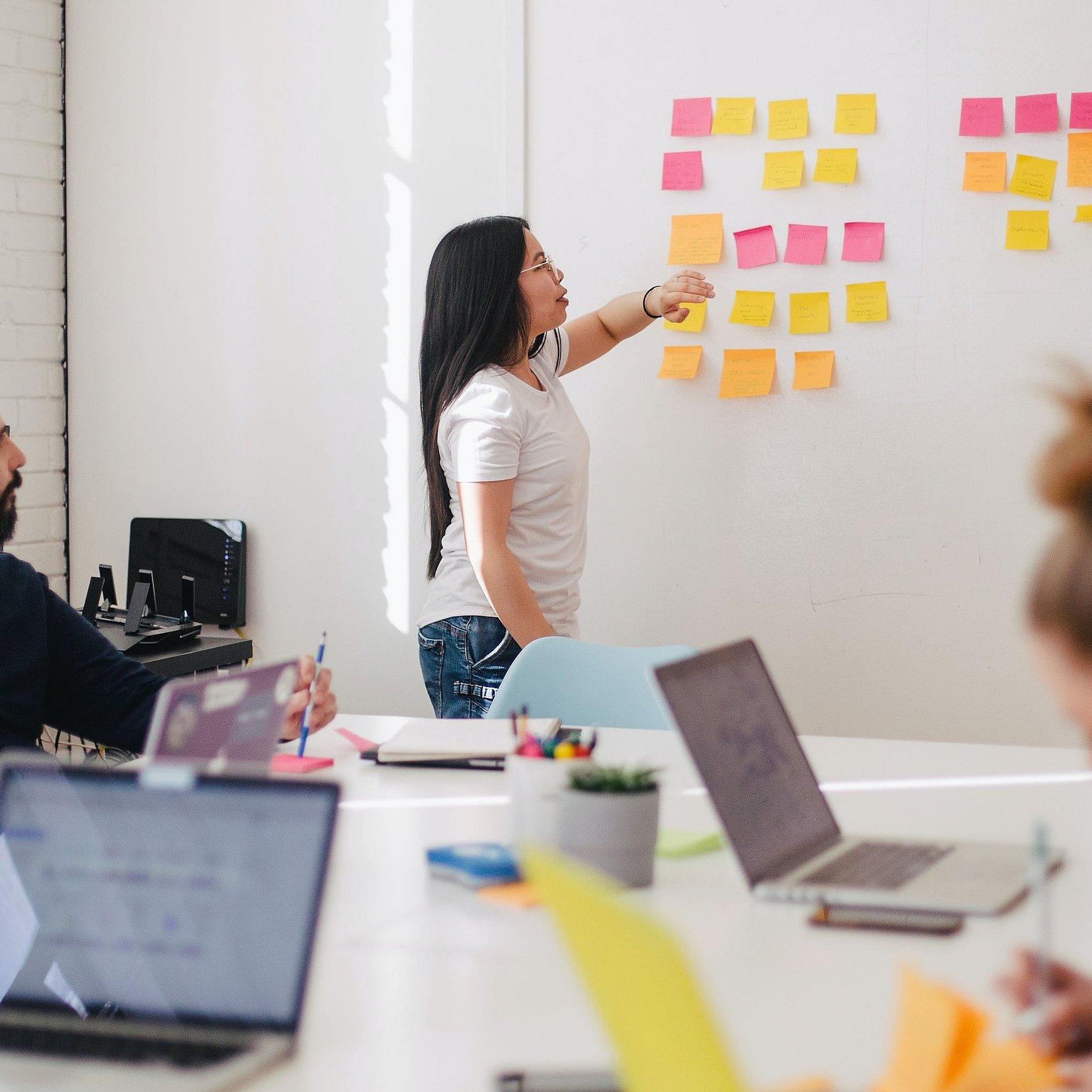 Datenschutz - Schulungen und Webinare Gruppe von Menschen in einer Schulung mit Notebooks und einem Whiteboard.