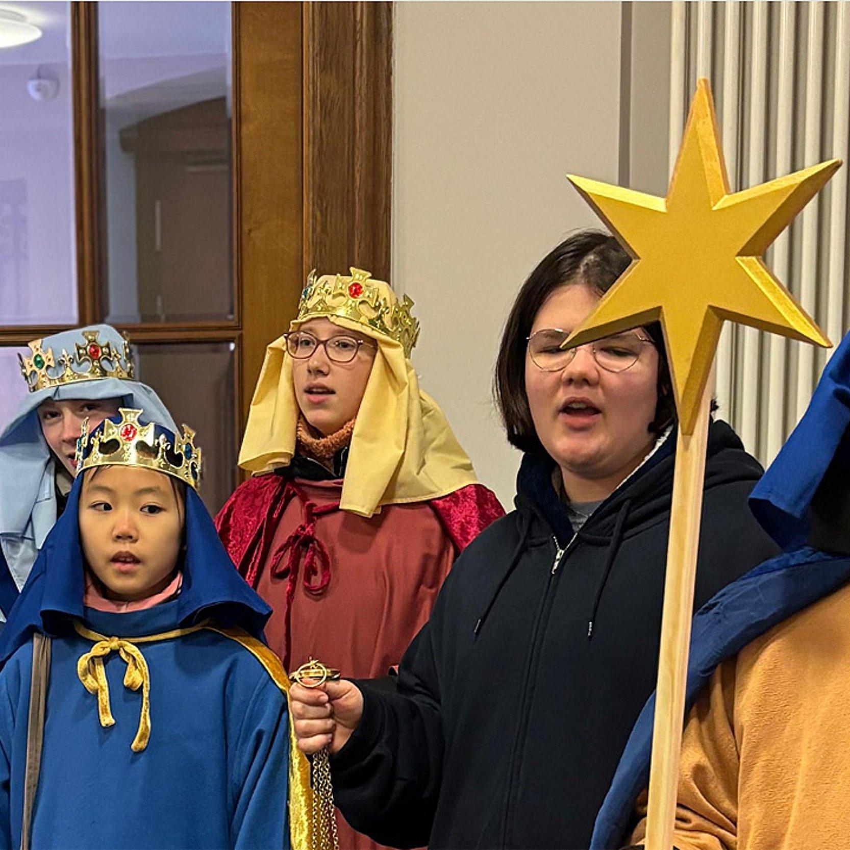 Sternsinger Gruppenbild mit Kindern, die als Könige verkleidet sind mit Pappstern an einem Stab