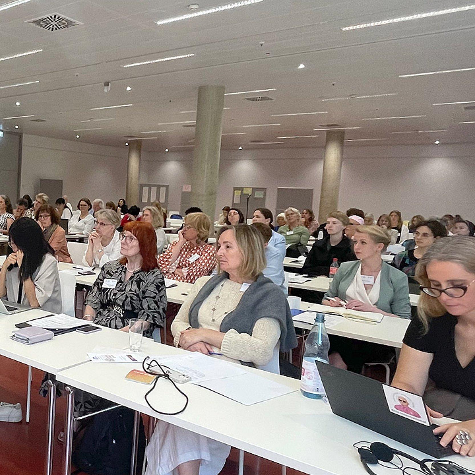Konferenz Konferenz mit Frauen an langen, weißen Tischen