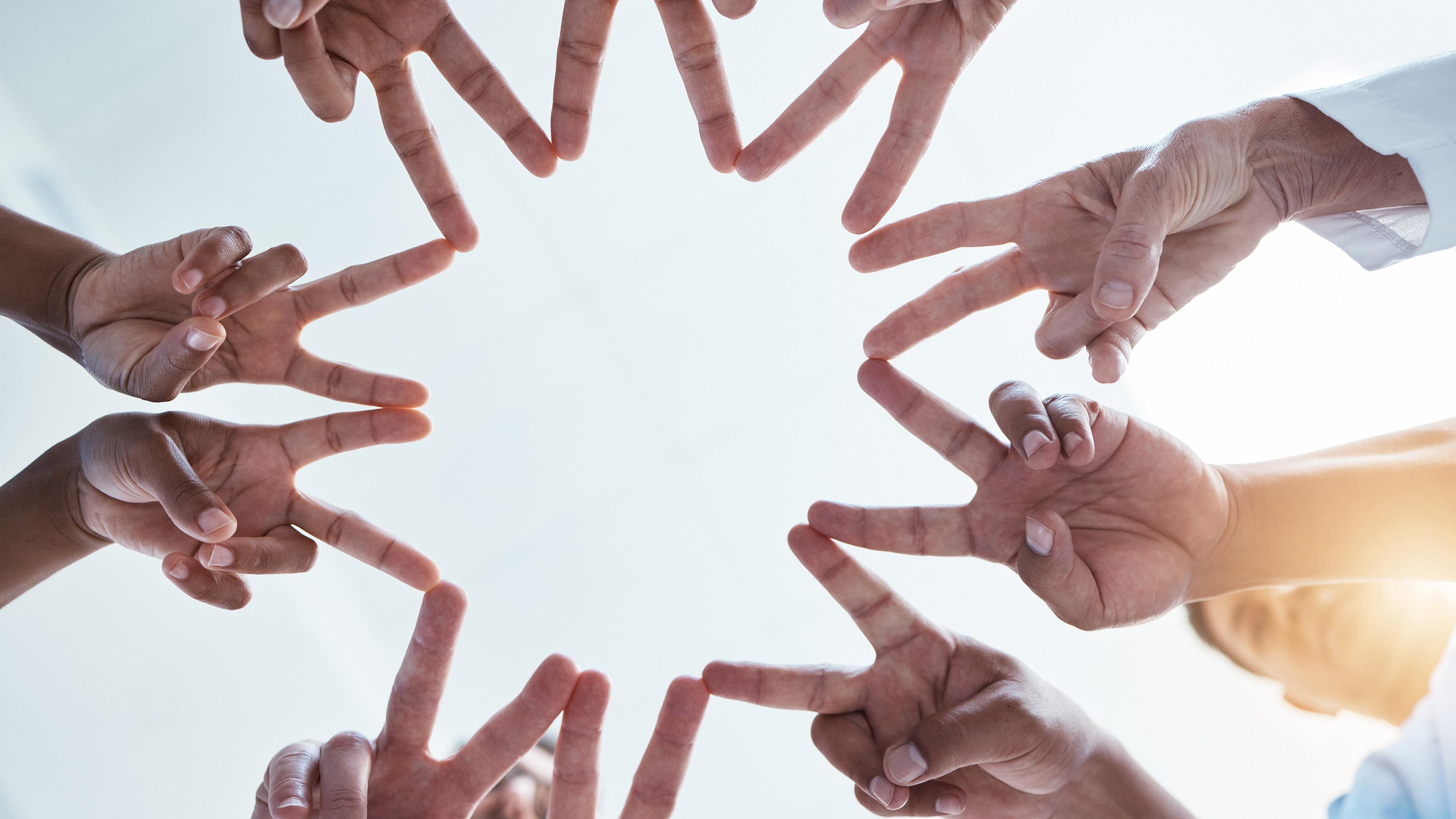 Viele Hände bilden einen Stern.