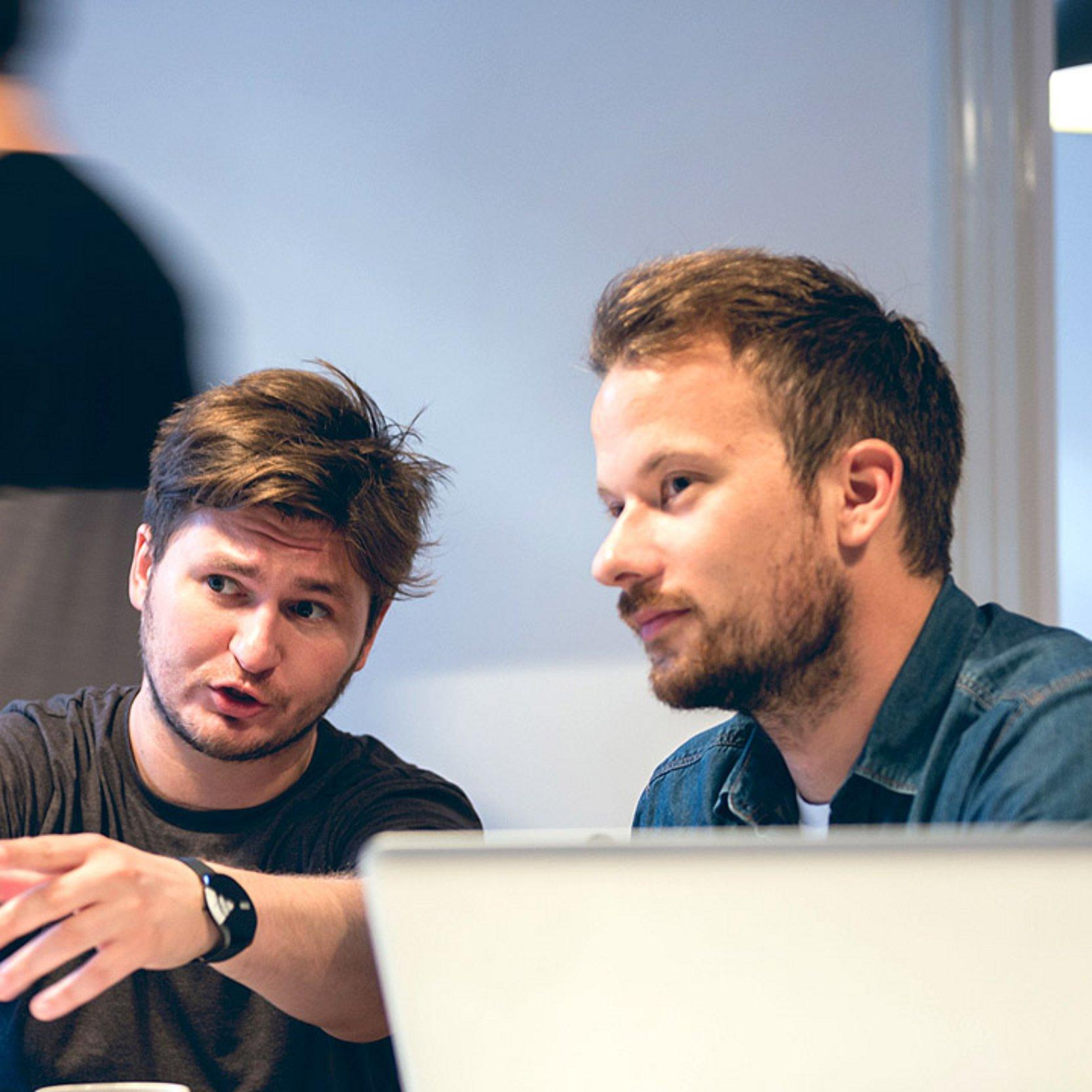 It-Spezialisten 2 Männer am PC, die miteinander sprechen