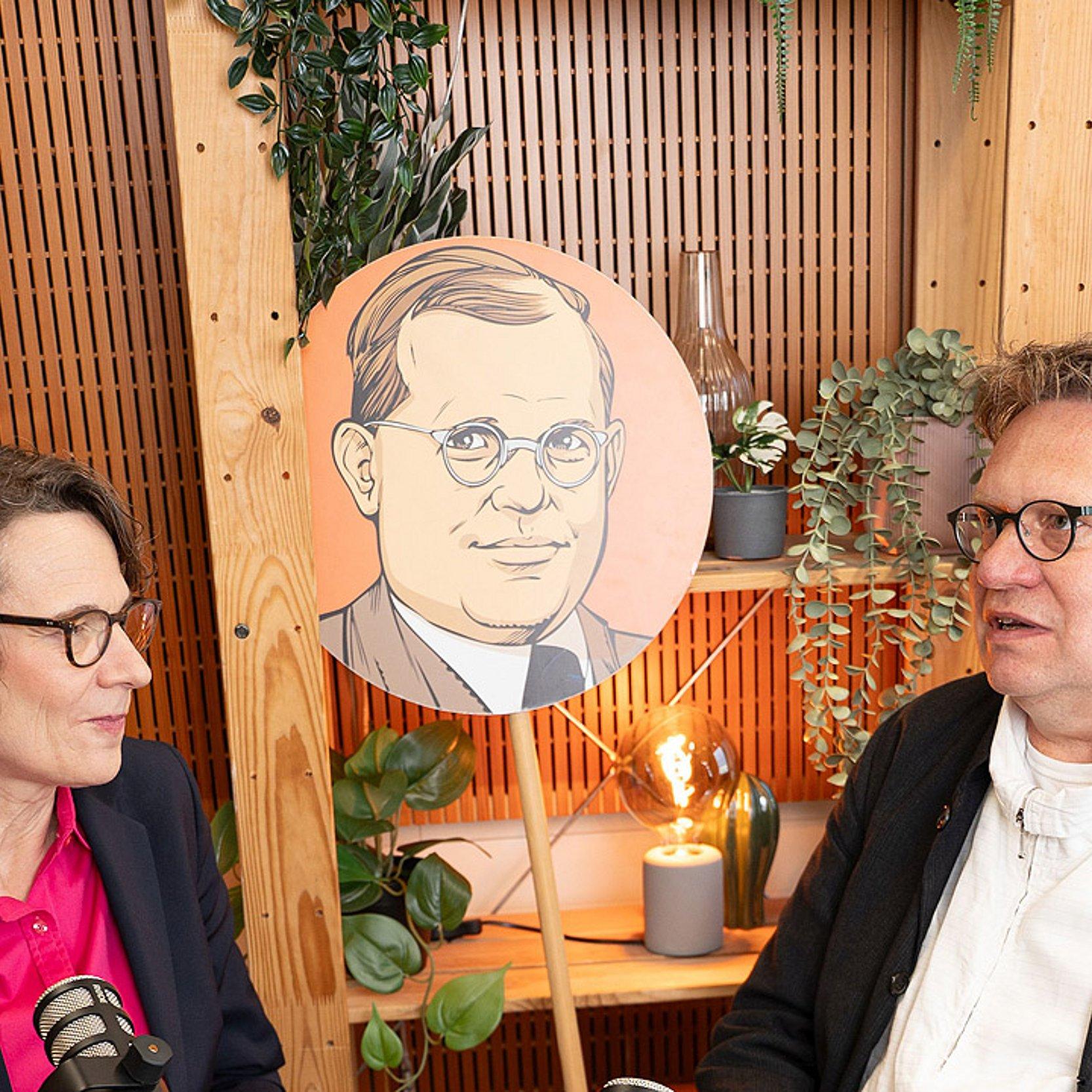Dietrich Bonhoeffer Bonnhoeffer-Grafik auf einem Schild in der Mitte, daneben Christiane Tietz und Frank Muchlinsky