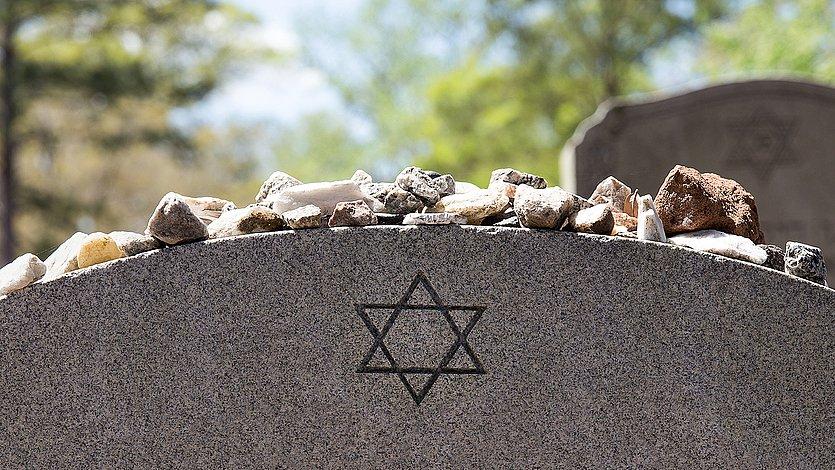 9. November Jüdischer Grabstein, auf dem Steine liegen