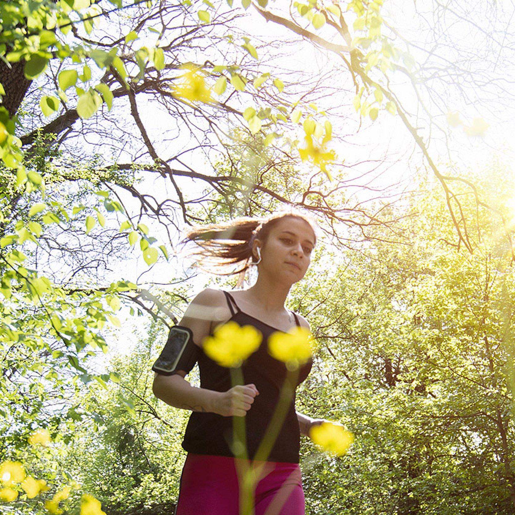Spirituelles Laufen Eine Frau joggt durch die blühende Natur