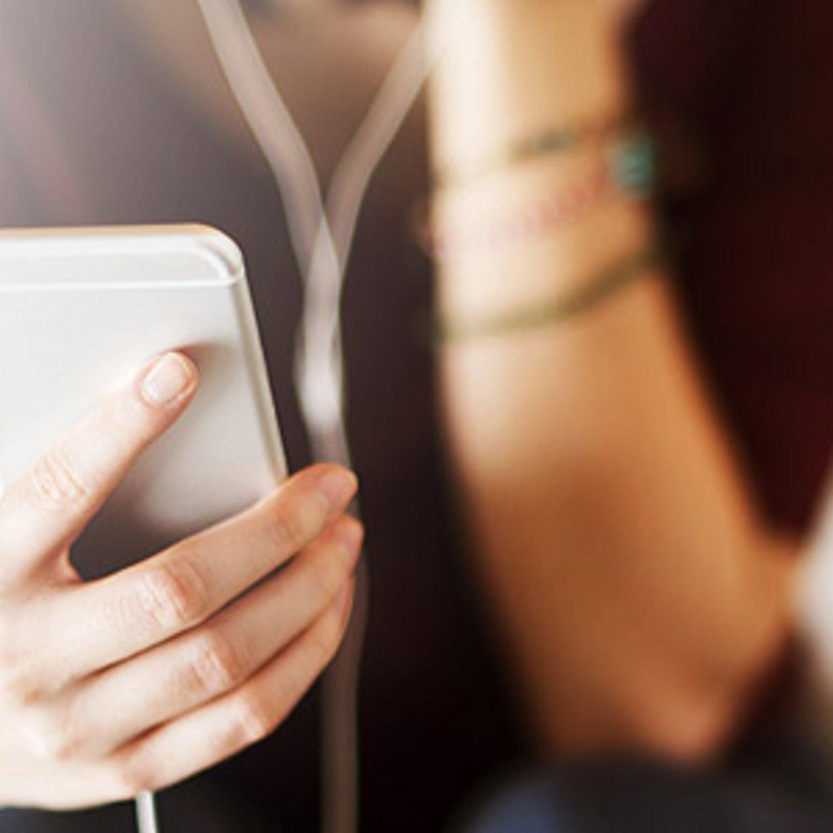 Chatseelsorge Hand einer jungen Frau, die ein Smartphone hält