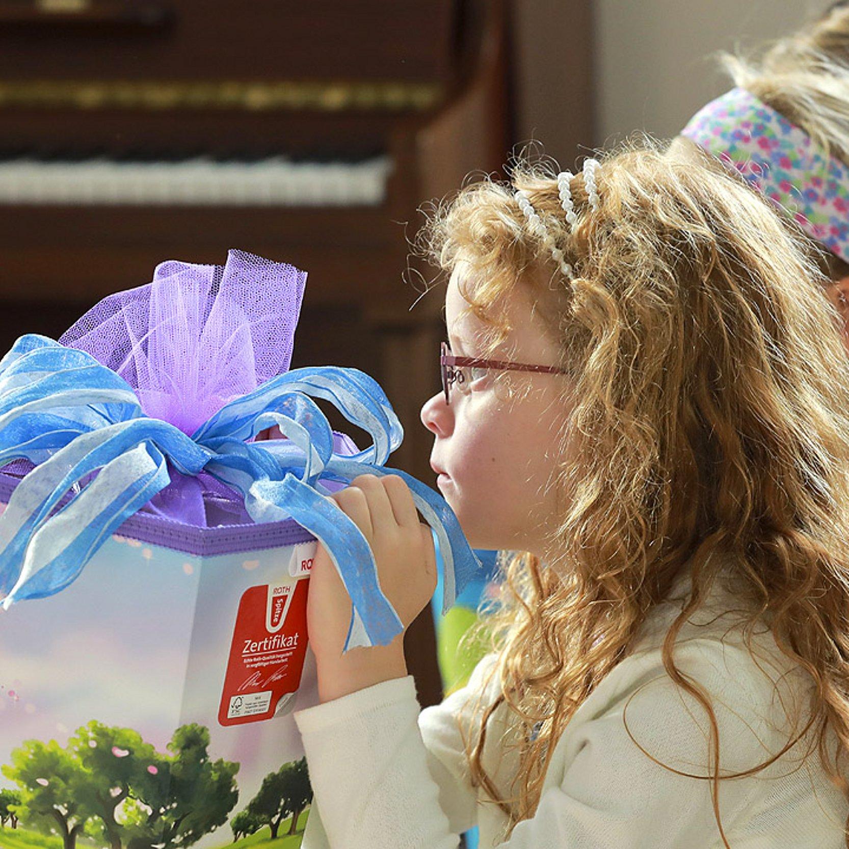 Einschulungsgottesdienst Ein Mädchen mit einer großen Schultüte sitzt auf einer Kirchenbank