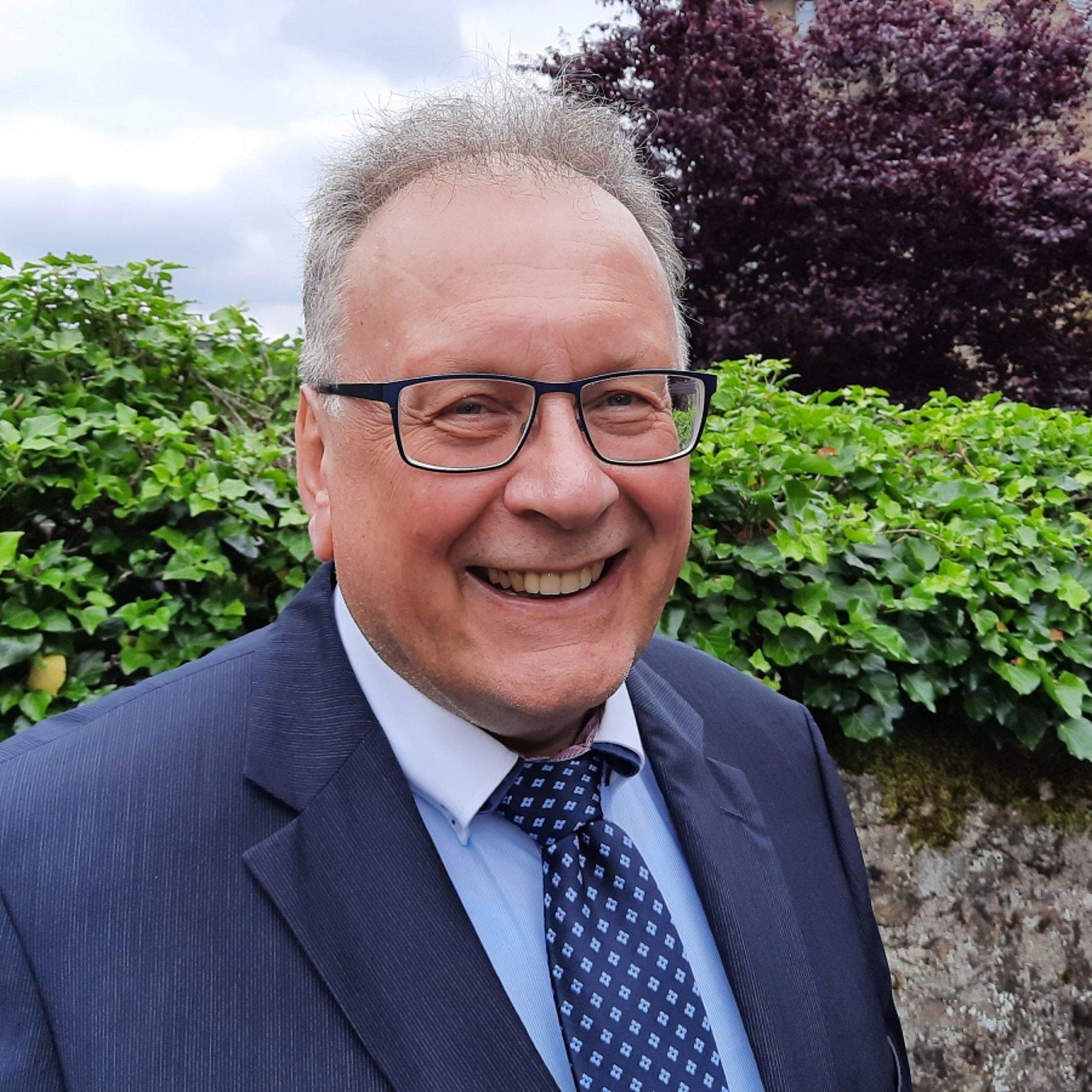 Professor Dr. Thorsten Moos Portrait vor einer Mauer des Theologischen Seminars Herborn.