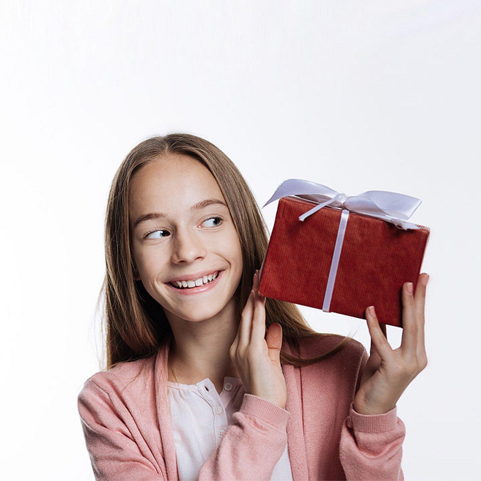 Geschenk zur Konfirmation Mädchen, da ein Geschenk hält
