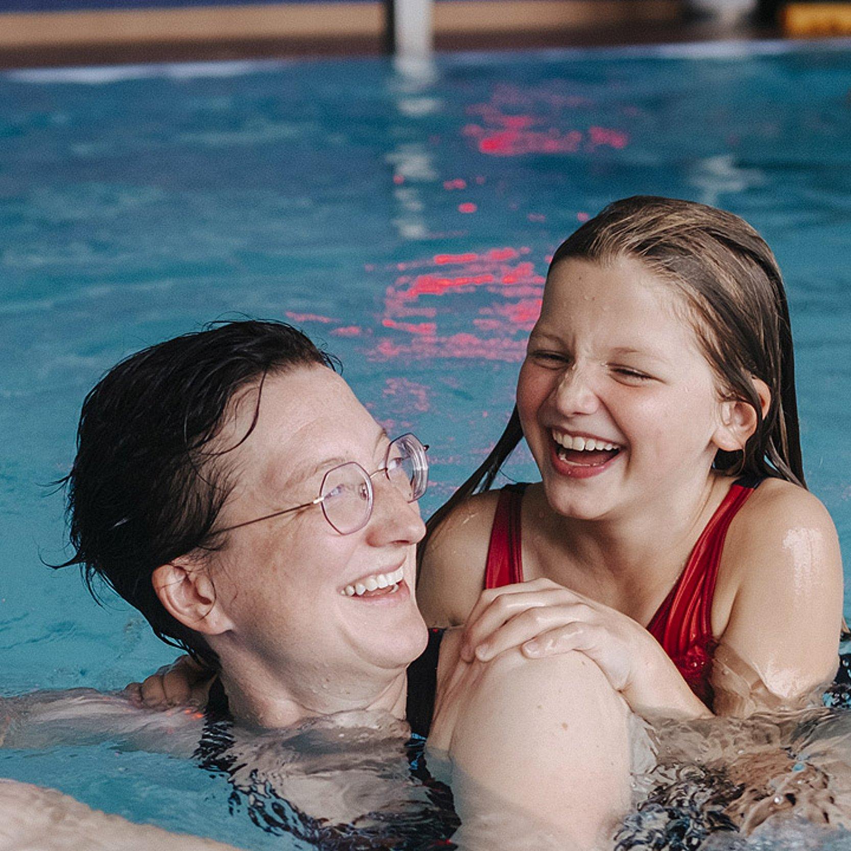Mutter-Kind-Kur Eine Frau schwimmt mit einem Kind im Schwimmbad