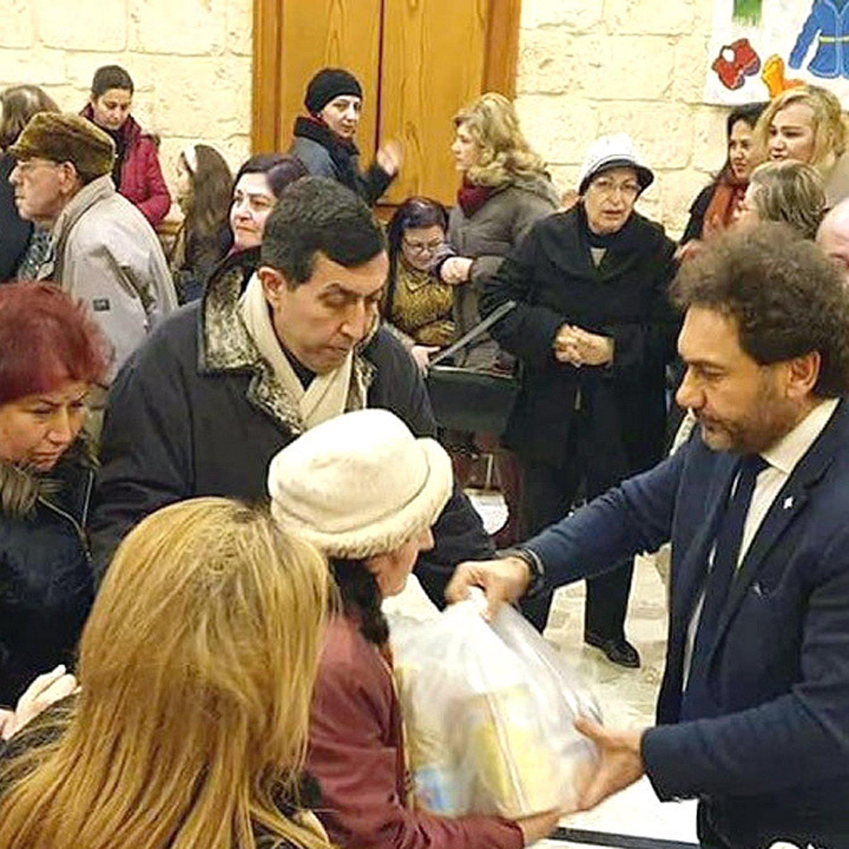 Lebensmittelspenden Ein Mann überreicht eine Tüte an andere Menschen