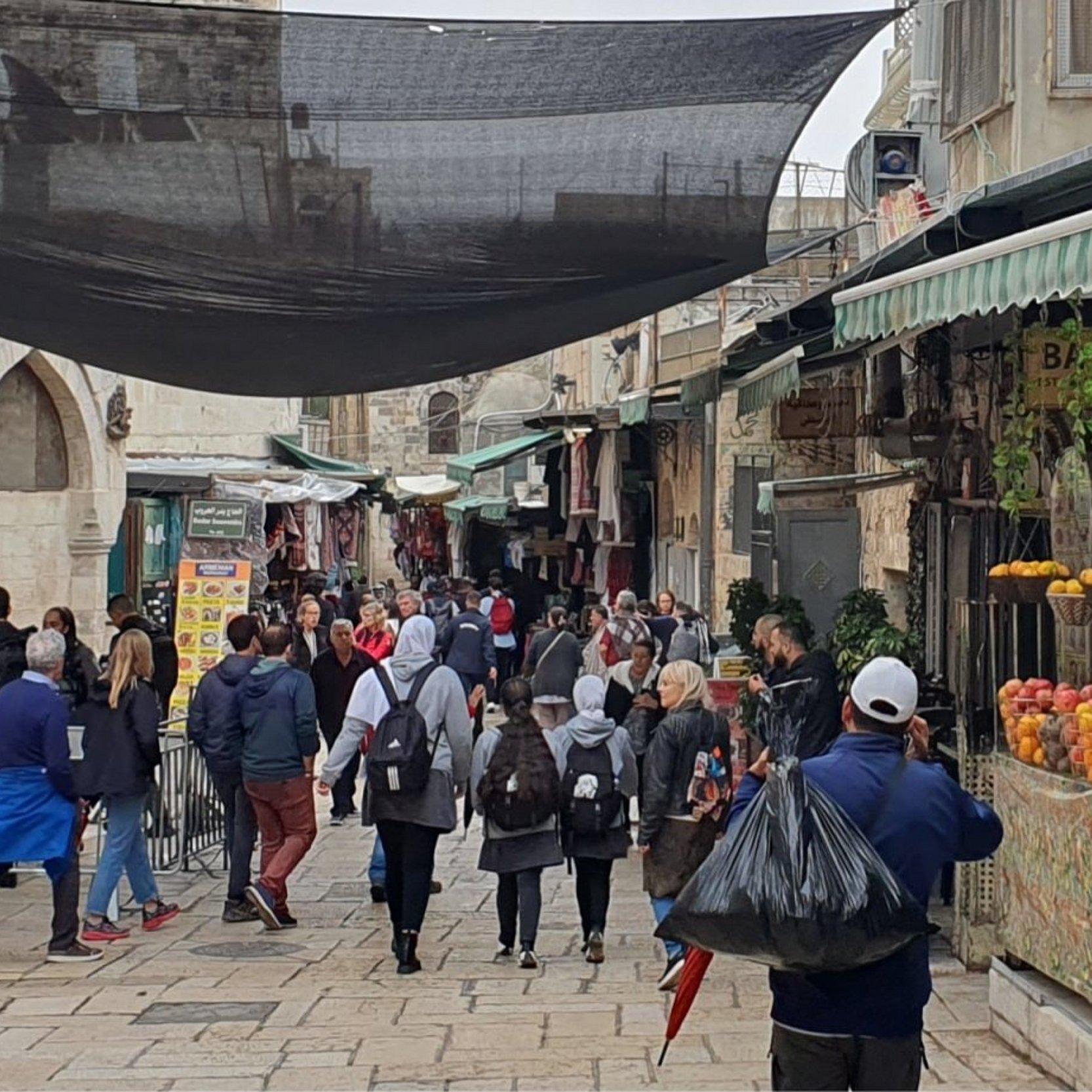 Ein belebte Straße in der Jerusalemer Altstadt. Israelische Sicherheitskräfte haben dort einen Posten errichtet. Touristen und Einheimische laufen vorbei.