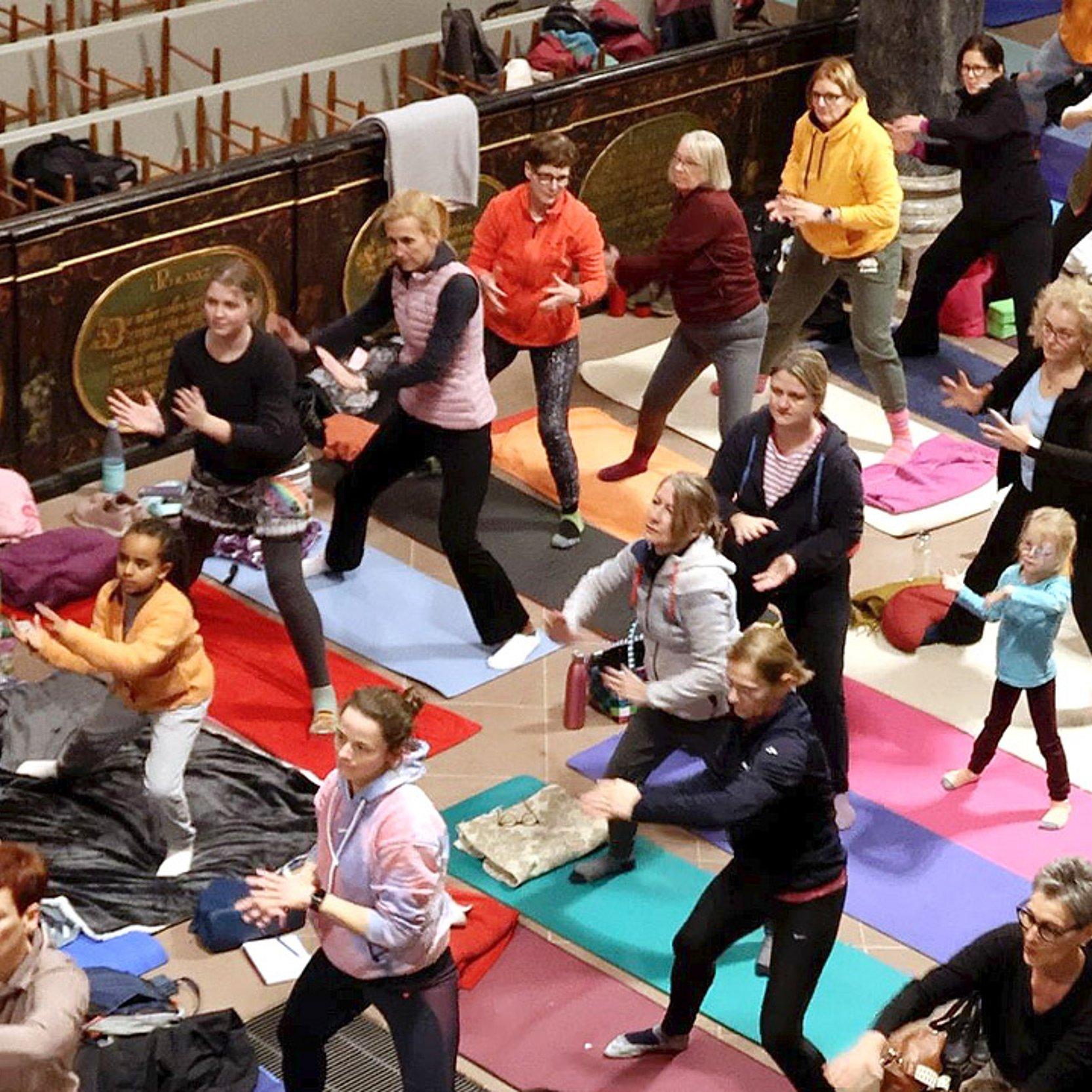 Yogagottesdienst Viele Menschen machen Yogaübungen in einer Kirche