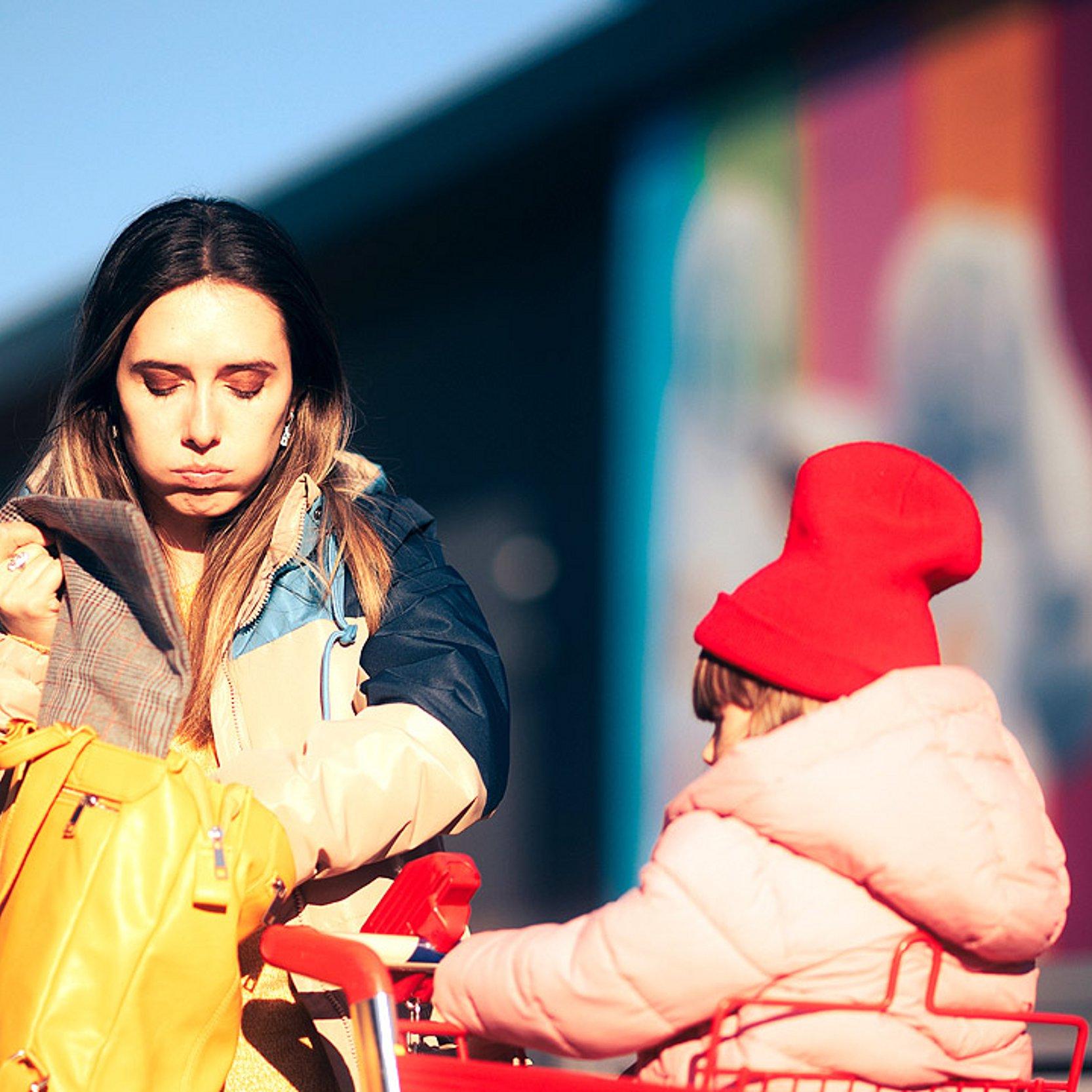 Rumänische Mutter mit Kind und Einkaufswagen