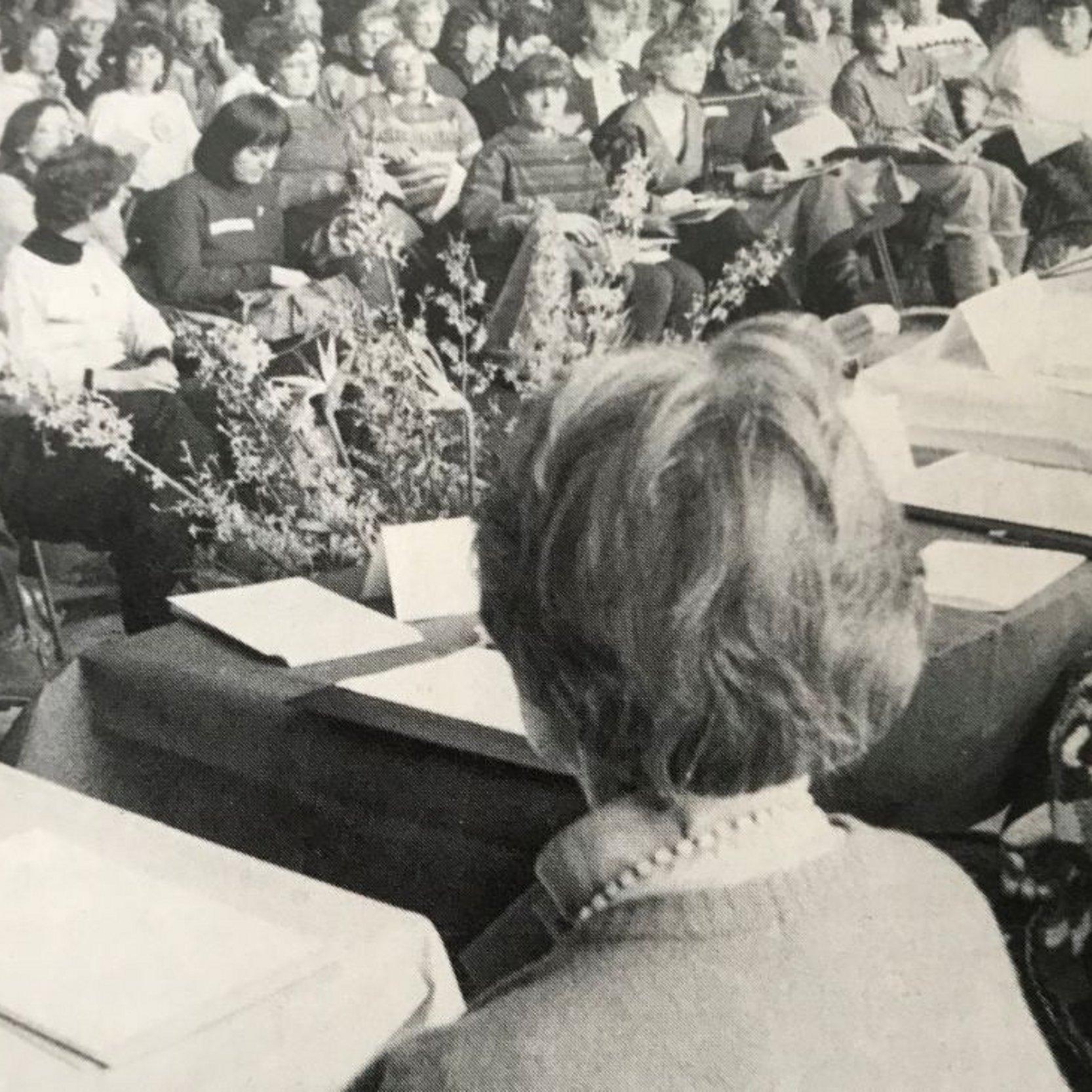 Erste Frauenanhörungin der EKHN Im Saal sitzen viele Frauen die auf ein Podium blicken, auf dem Podium sieht man zwei Frauen von hinten. Das Bild ist schwarz-weiß.