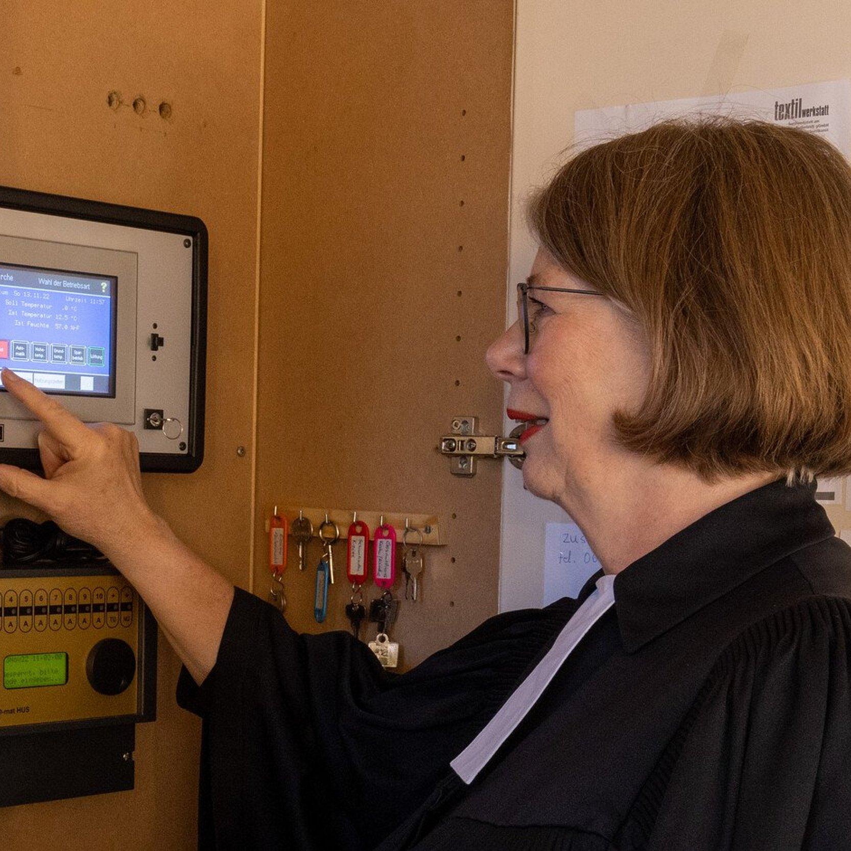 Energiesparen in der Kirche Energiesparen in der Kirche. In der Nazarethkirche in Frankfurt Eckenheim wird die Temperatur des Kircheninnenraumes über ein Thermometer gemessen und und die moderne Heizung lässt sich über ein Display steuern. Gemeindepfarrerin Christine Streck-Spahlinger zeigt die Heizungssteuerung im Kirchenraum. und deutet mit den Finger auf das Display.