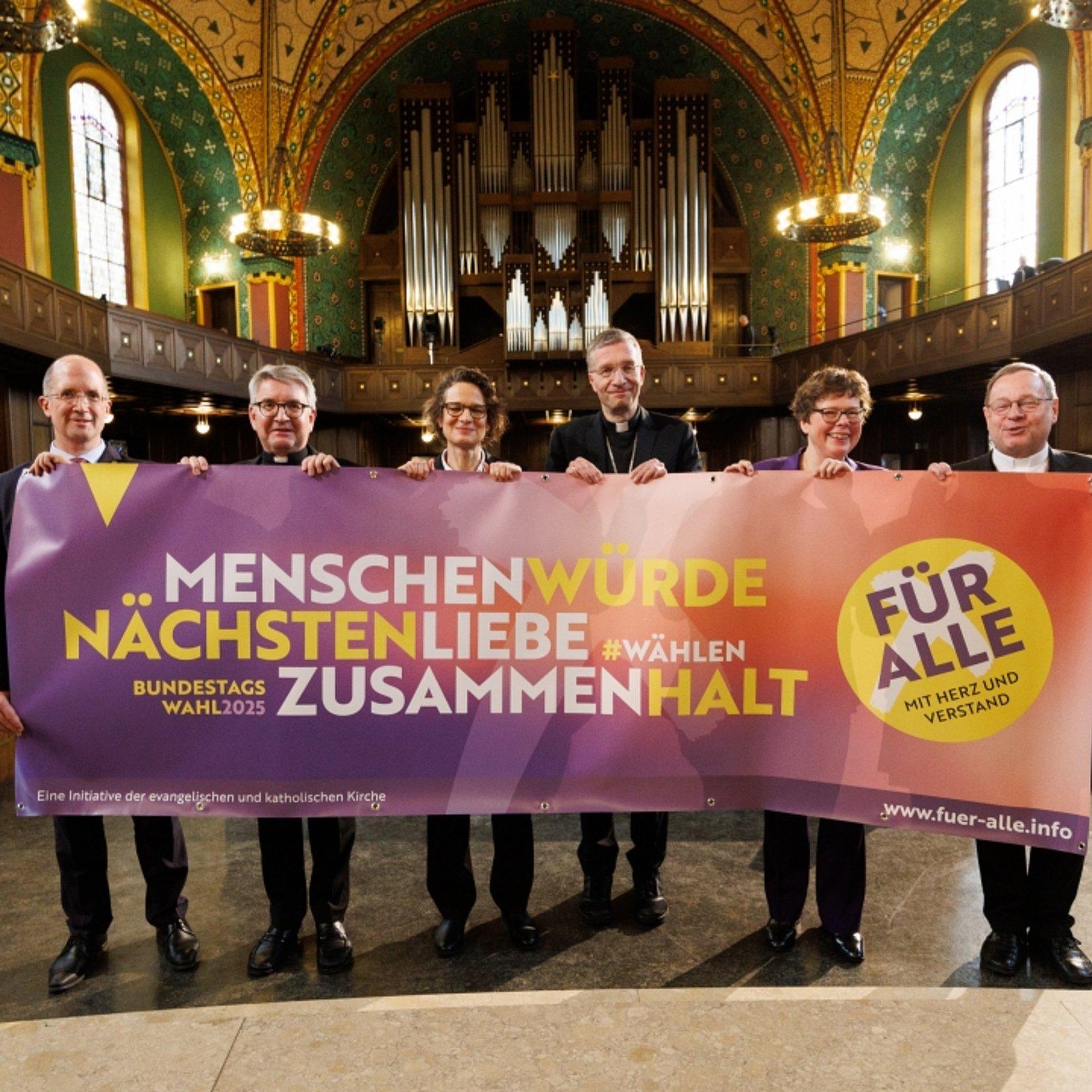 Gemensame Aktion zur Bundestagswahl Gruppenbild, die Kirchenleitenden halten ein großes Banner vor sich.
