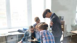 Schüler arbeiten an einem Projekt, sitzen zusammen und sprechen miteinander