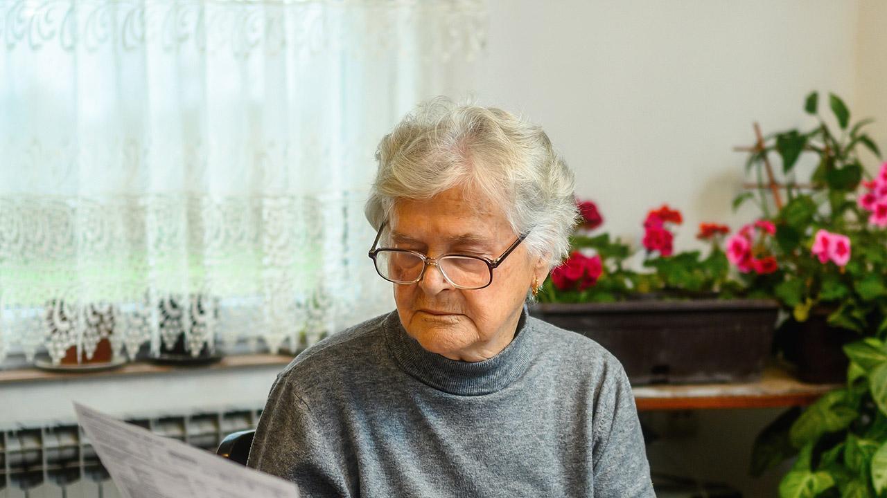 Eine Seniorin liest ein offizielles Schreiben