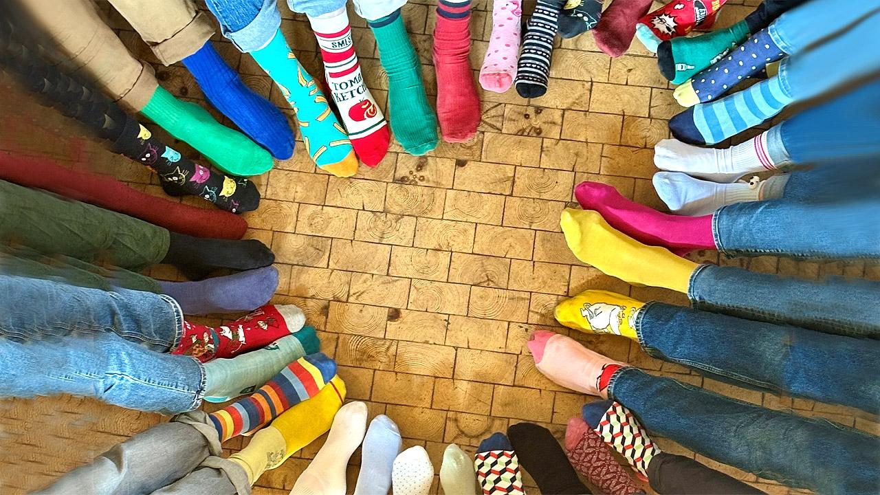 Viele Füße mit bunten Socken formen ein Herz