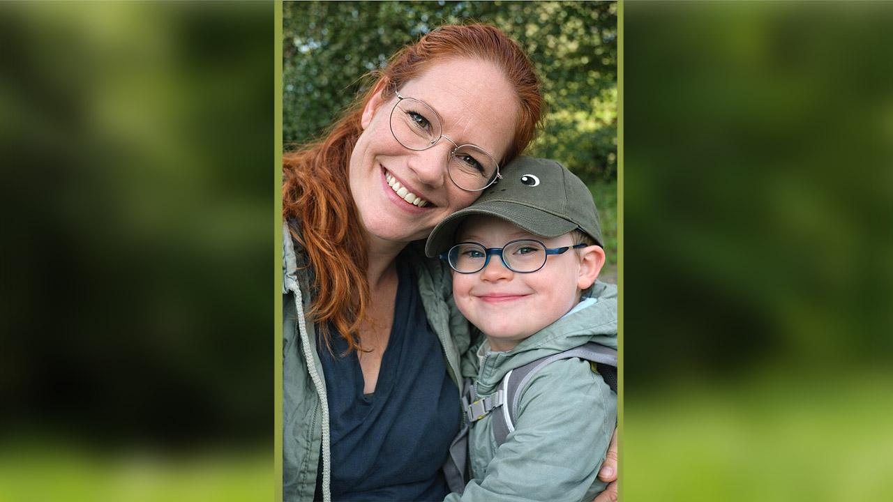 Liebevolle Beziehung Ein kleiner Junge kuschelt sich an seine Mutter, beide lächeln innig