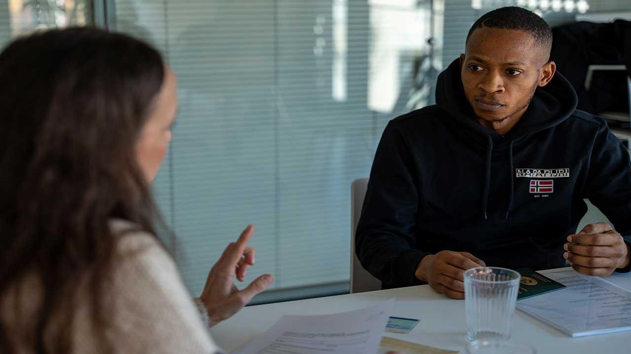 Gesprächssituation: Eine Frau berät einen Geflüchteten