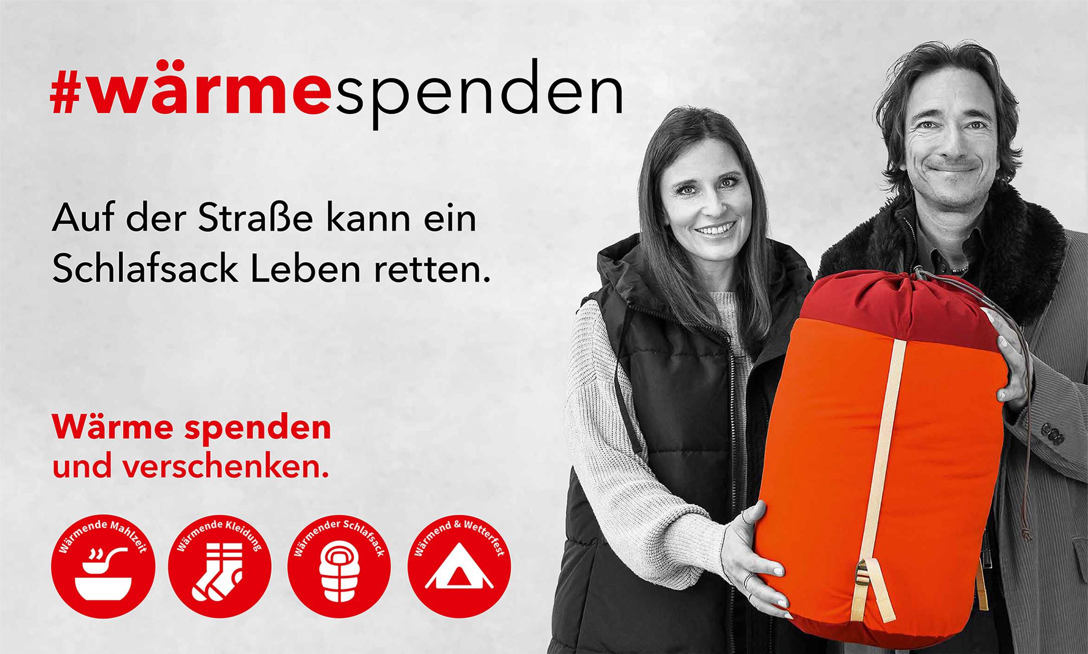 Aktion #wärmespenden 2024 Kampagne Julia Nestle und Nicolai Friedrich mit rotem Schlafsack. Kampagneninfos