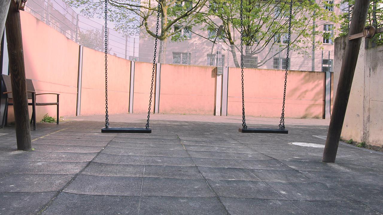 Ausstellung gegen Antisemitismus Zwei Schaukeln auf einem leeren Schulhof