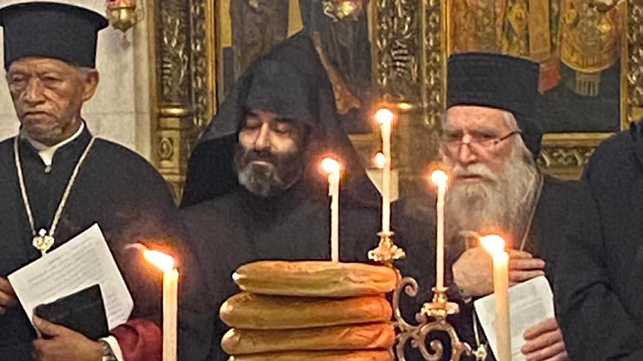 Gebetswoche zur Einheit der Christen Orthodoxe Geistliche in schwarzen Roben hinter Kerzen und einem Stapel Broten