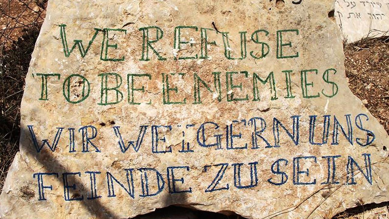 Friedensbotschaft Worte auf einem Stein: Wir weigern uns, Feinde zu sein.