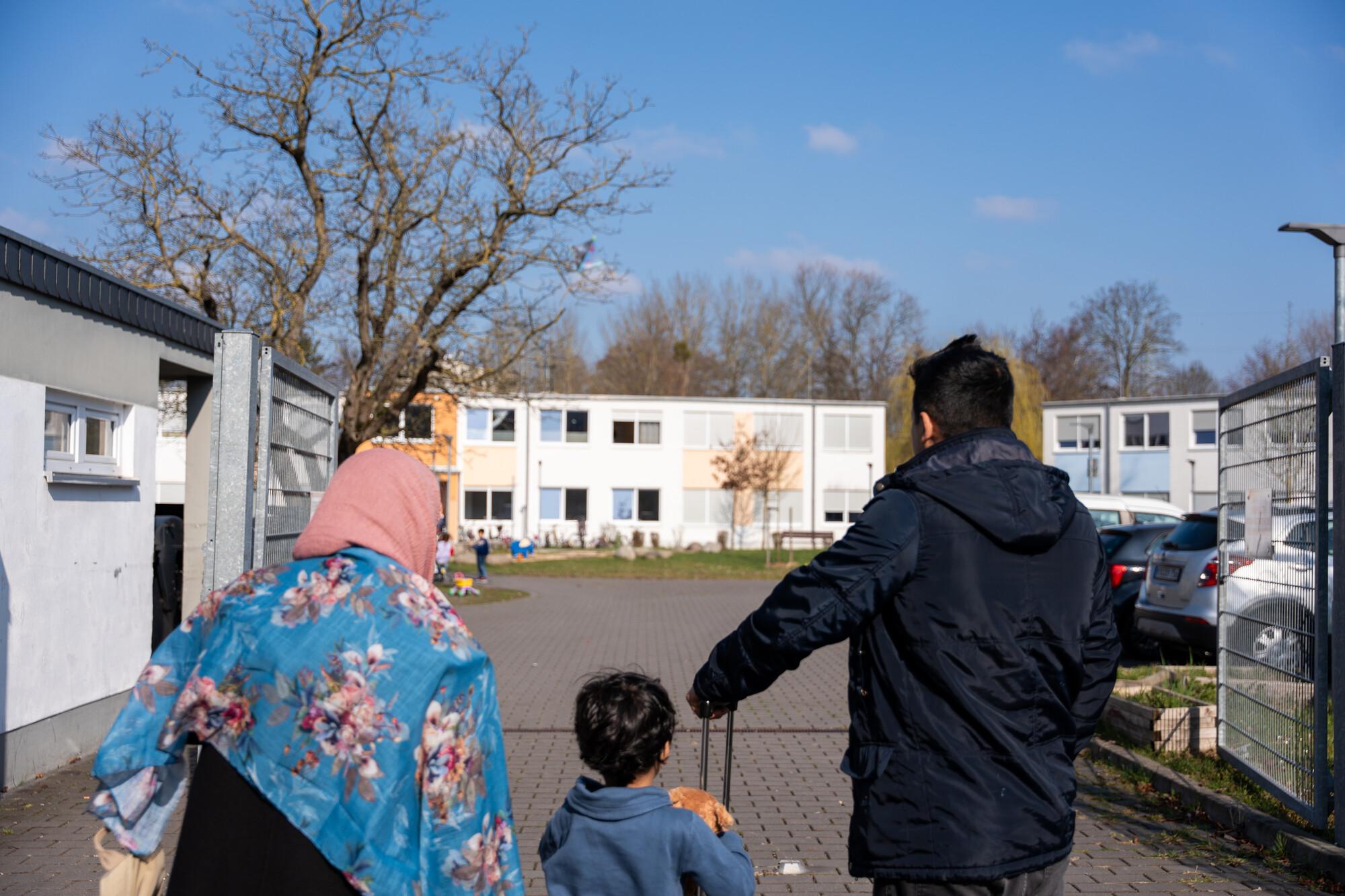 Vater, Mutter und Kind kommen in einer Unterkunft an