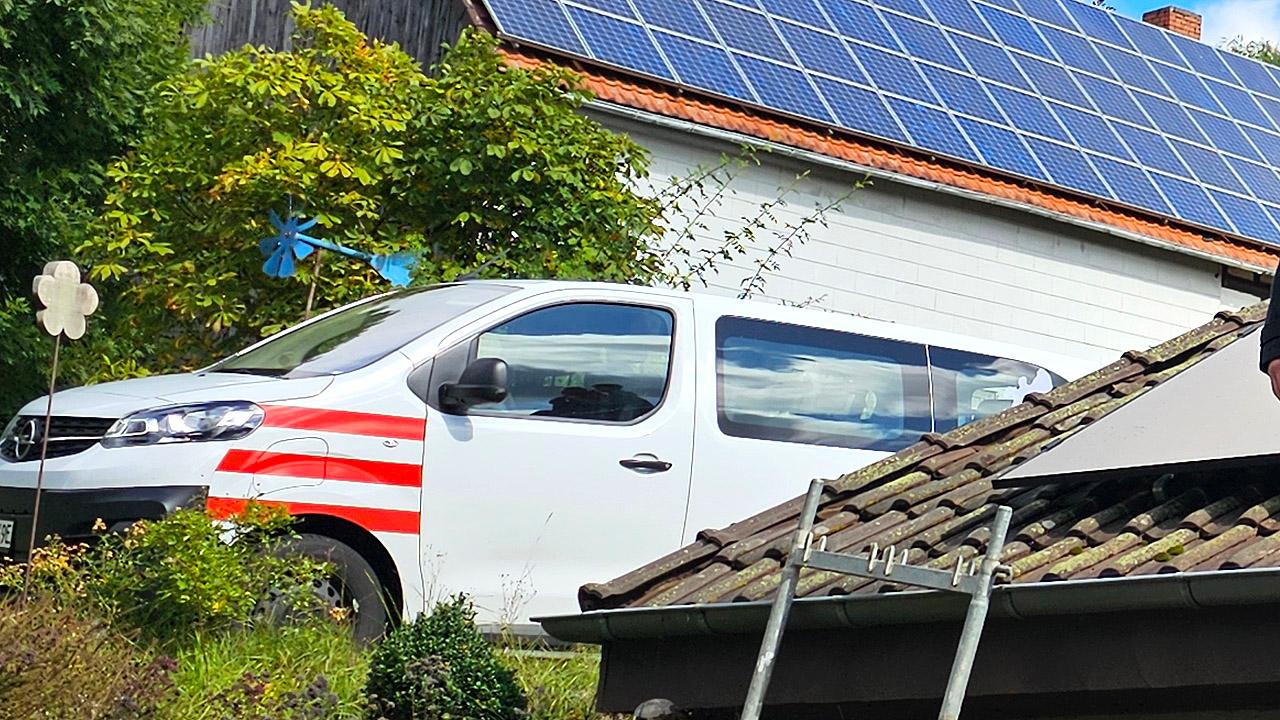 Ein weißer Klein-Bus mit roten Streifen